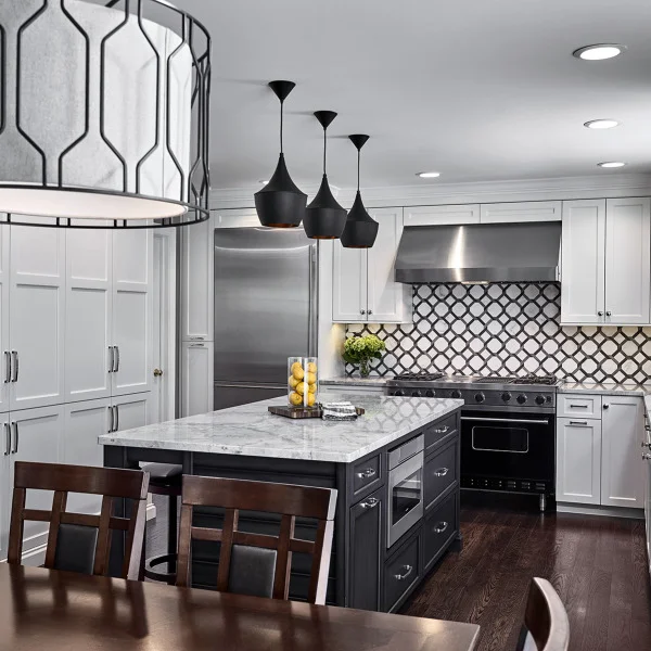 Palatine kitchen remodel featuring white cabinets, dark island with marble countertop, black pendant lights, and hardwood flo