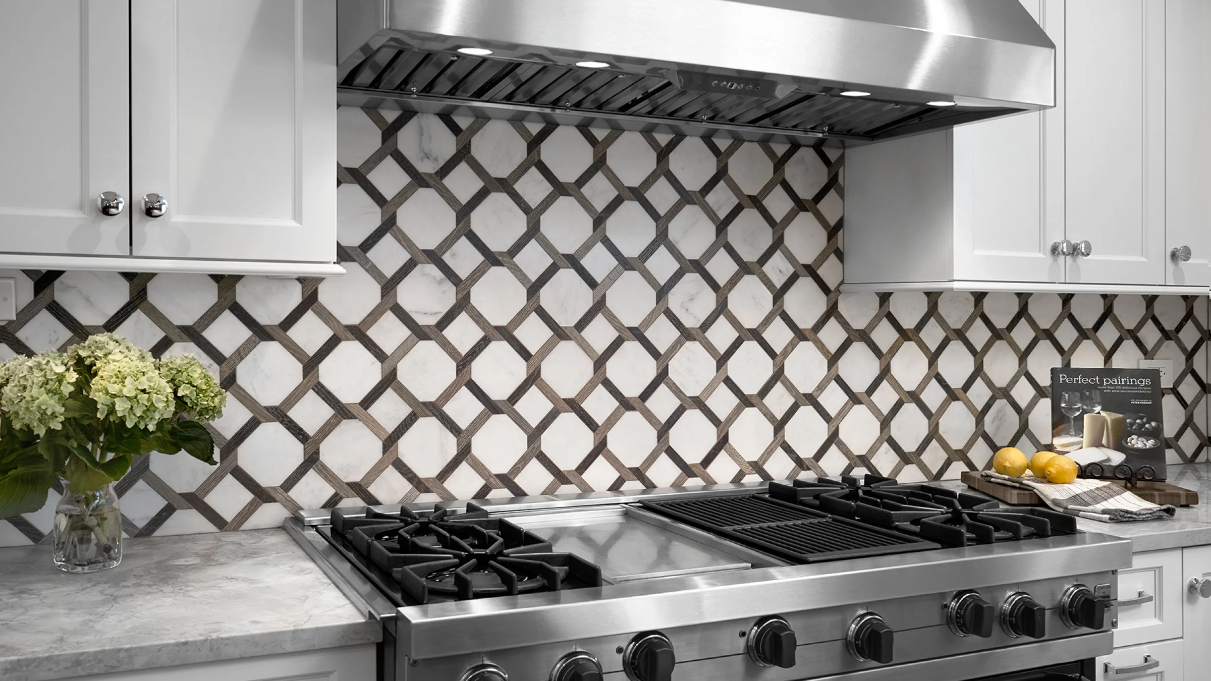 Palatine kitchen remodel with custom backsplash, stainless steel range, white cabinets, and marble countertops.