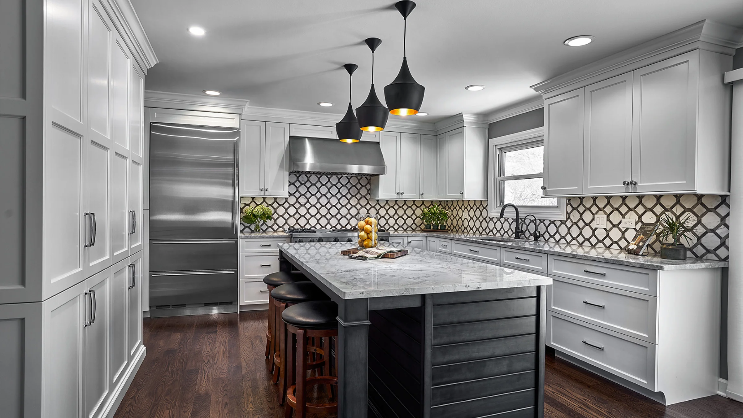 Modern kitchen remodel in Palatine, IL featuring white cabinets, marble countertop, island with seating, and stainless steel 