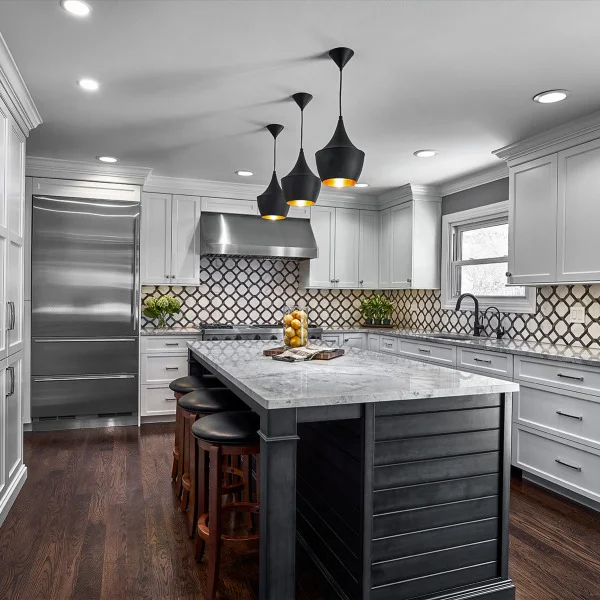 Modern kitchen remodel in Palatine, IL featuring white cabinets, marble countertop, island with seating, and stainless steel 