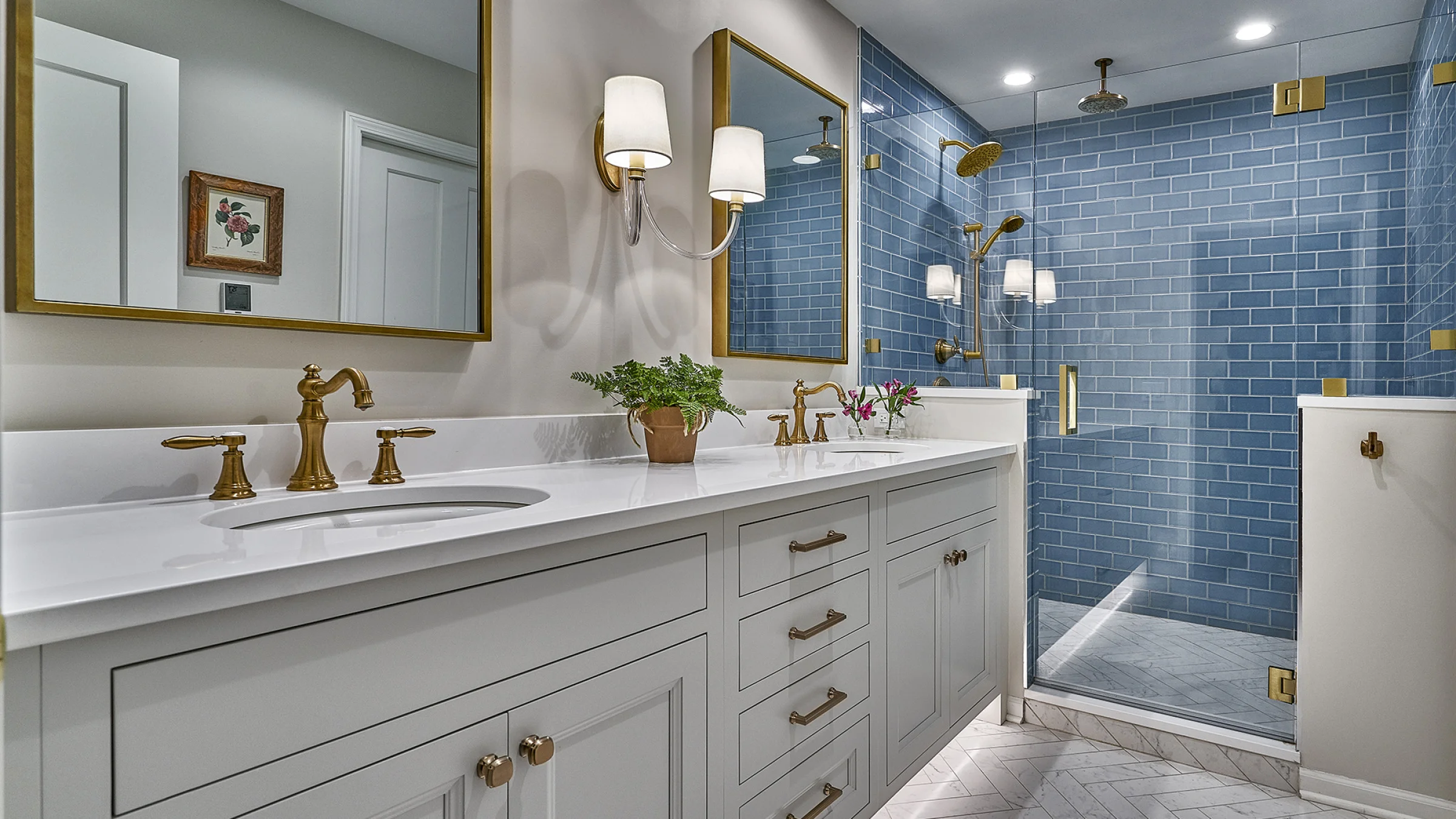 Western Springs bathroom remodel: double vanity, white quartz countertop, blue tile shower, gold fixtures, herringbone floor.