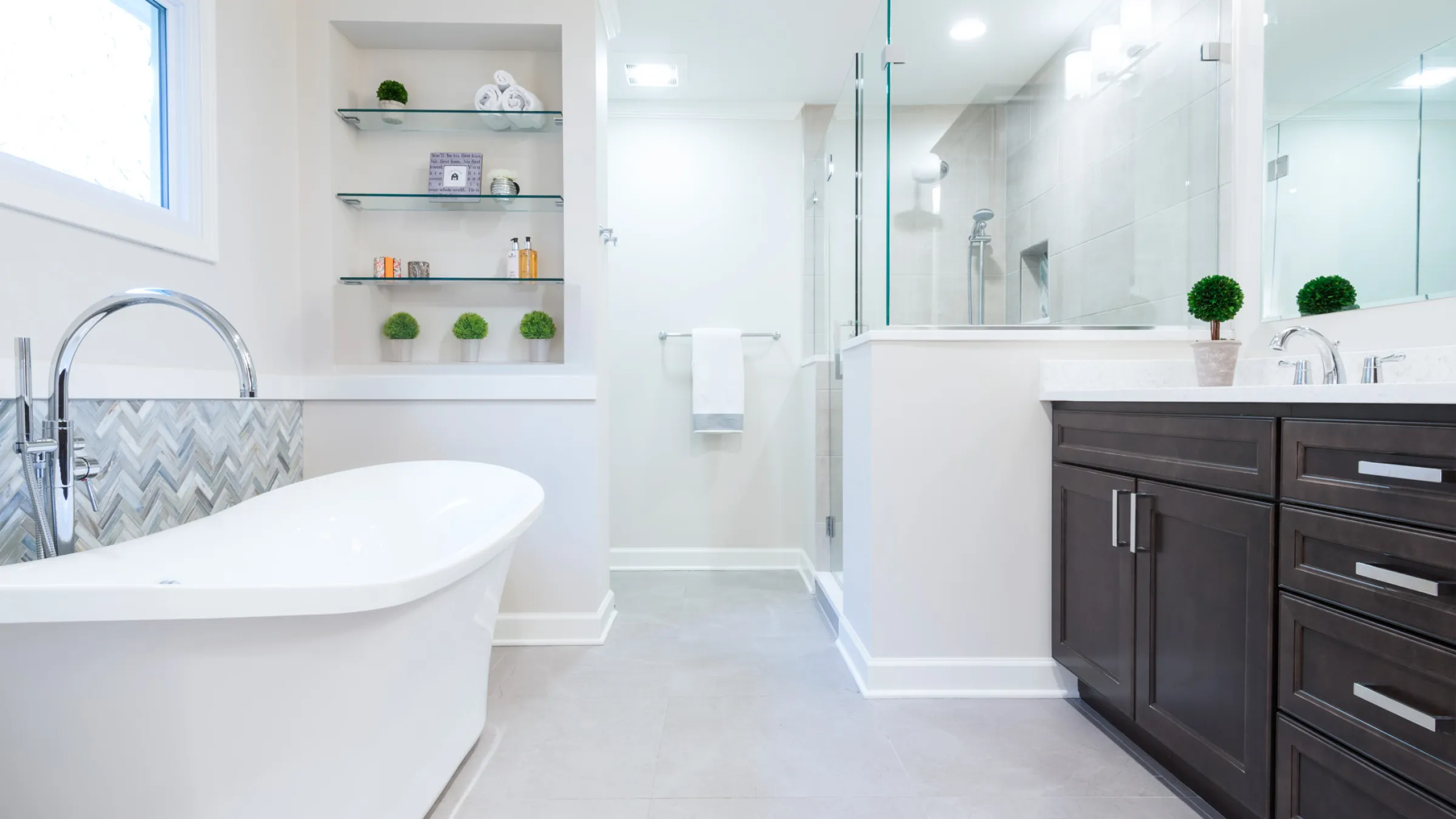 Modern bathroom remodel in Palatine, IL featuring a freestanding tub, glass shower, and dark wood vanity.