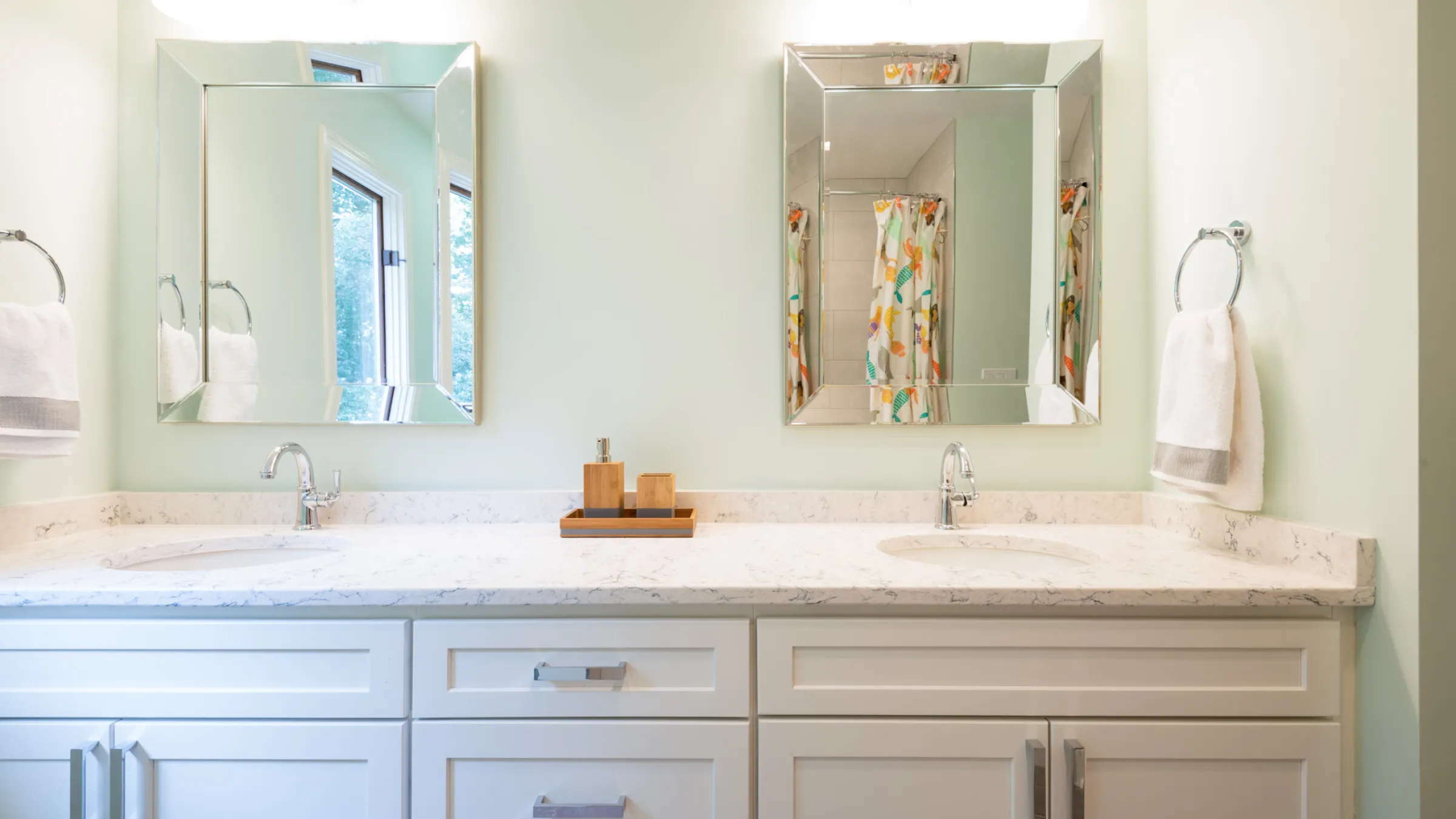 Modern bathroom remodel with white cabinets, quartz countertop, dual sinks, and beveled mirrors in Palatine, IL.