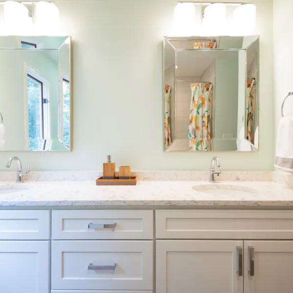 Modern bathroom remodel with white cabinets, quartz countertop, dual sinks, and beveled mirrors in Palatine, IL.