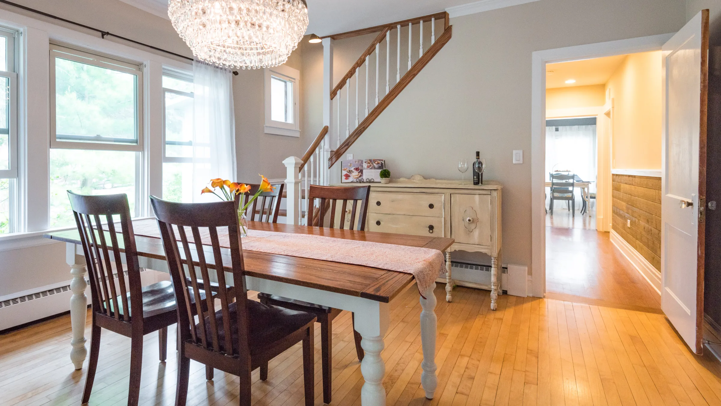 Palatine home remodel: Dining room with wood table, chandelier, and refinished hardwood floors. Historic charm, modern update