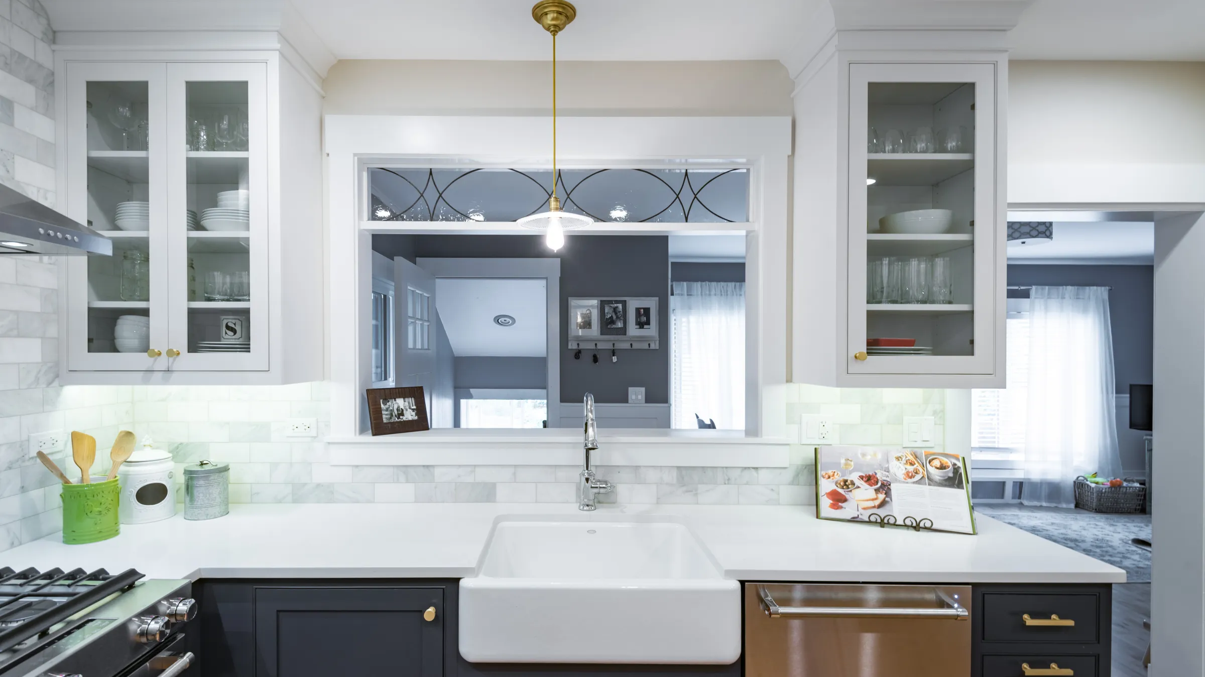 Palatine kitchen remodel featuring white cabinets, farmhouse sink, marble backsplash, and contrasting dark gray island.