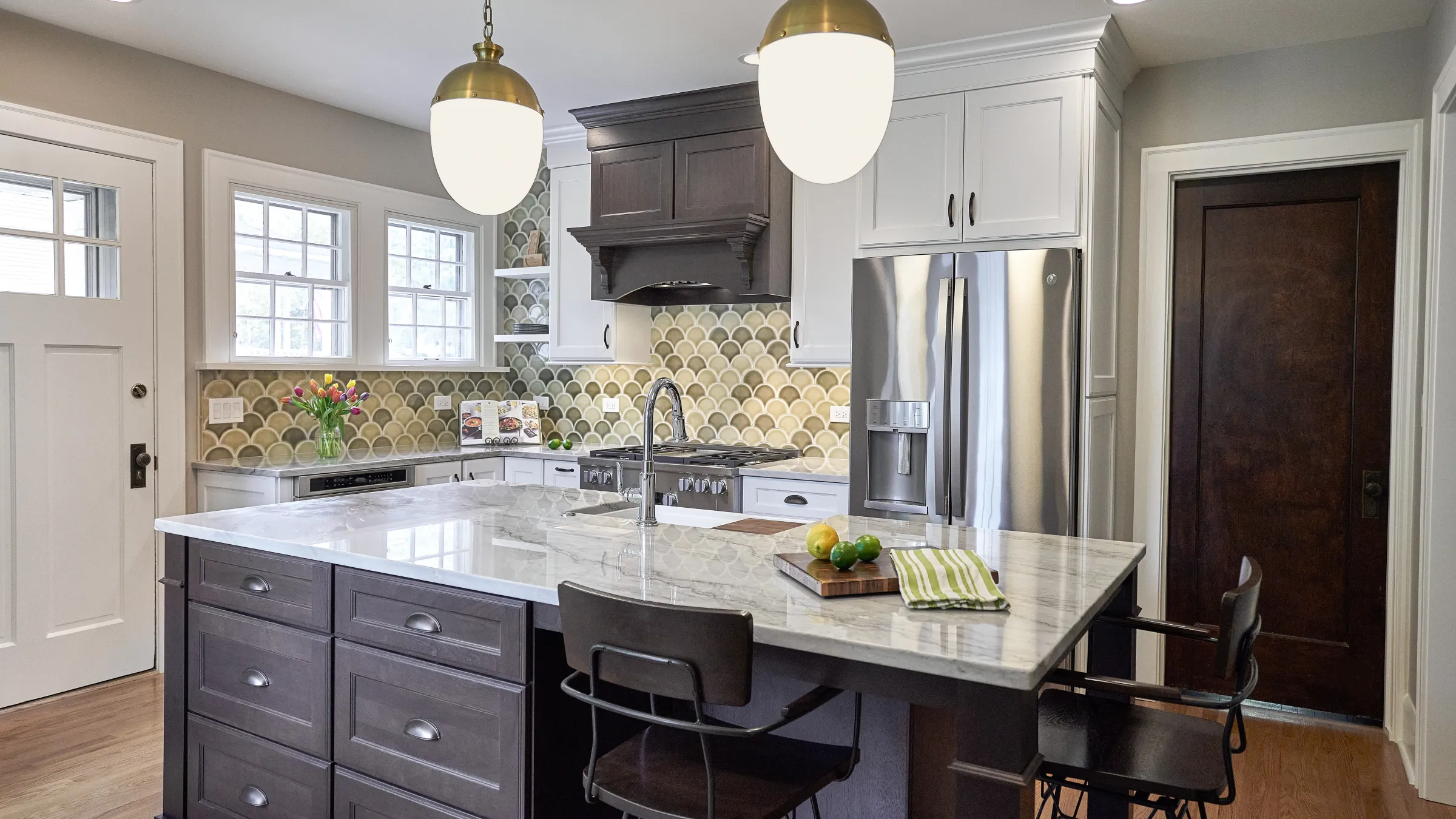 Arlington Heights kitchen remodel with gray island, marble countertops, bronze pendant lights, and custom tile backsplash.