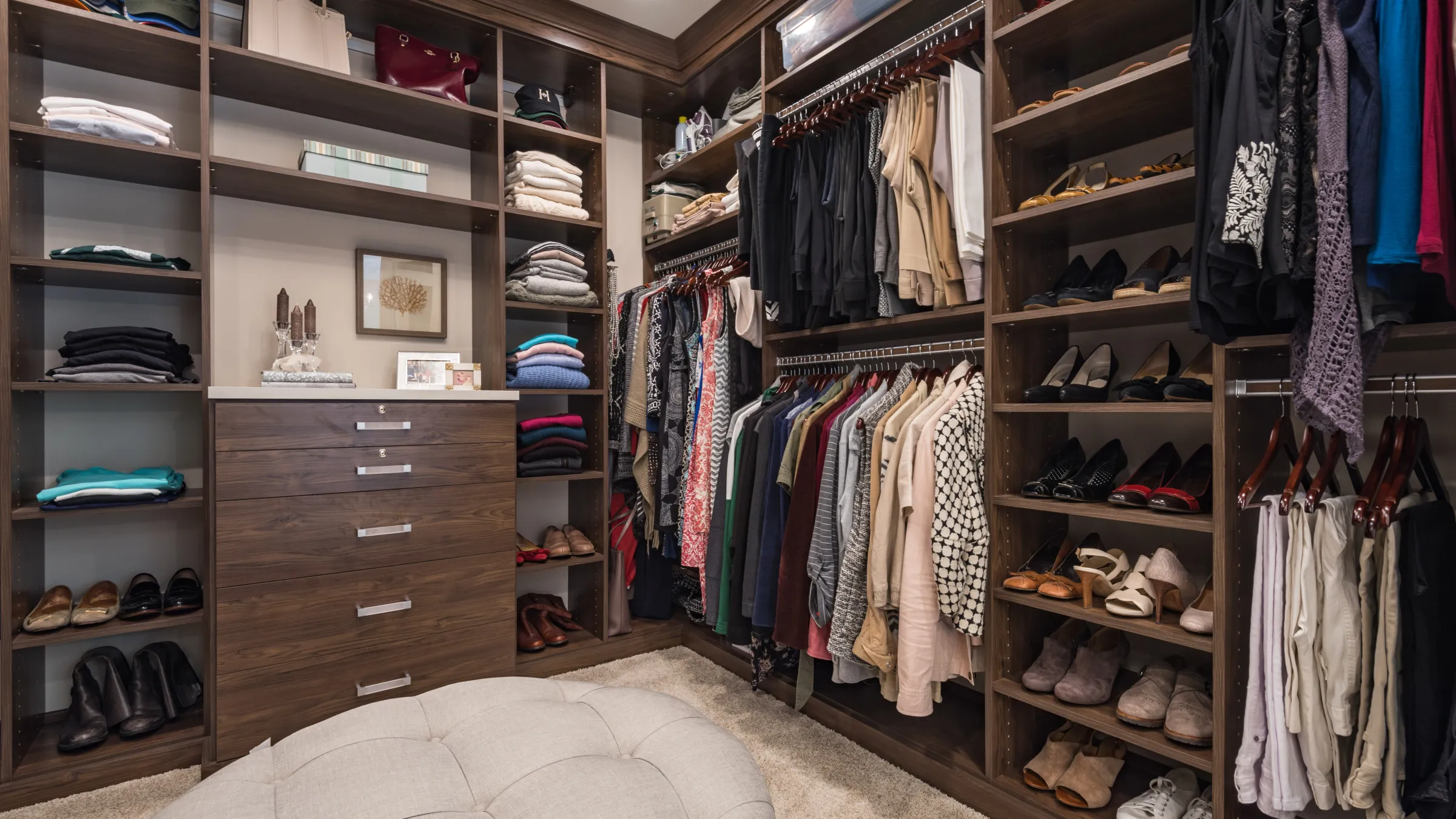 Custom walk-in closet with dark wood cabinets, shelving, drawers, and shoe storage in Palatine, IL bathroom remodel.
