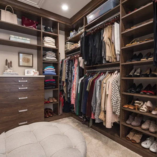 Custom walk-in closet with dark wood cabinets, shelving, drawers, and shoe storage in Palatine, IL bathroom remodel.