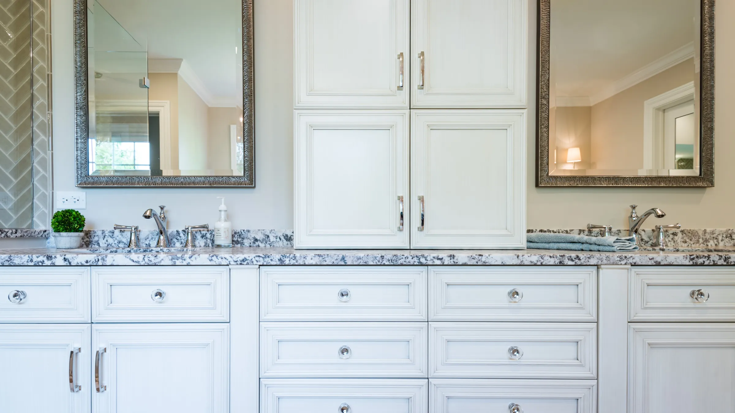 Bathroom remodel with white custom cabinets, marble countertop, dual sinks, and framed mirrors in Palatine, IL.