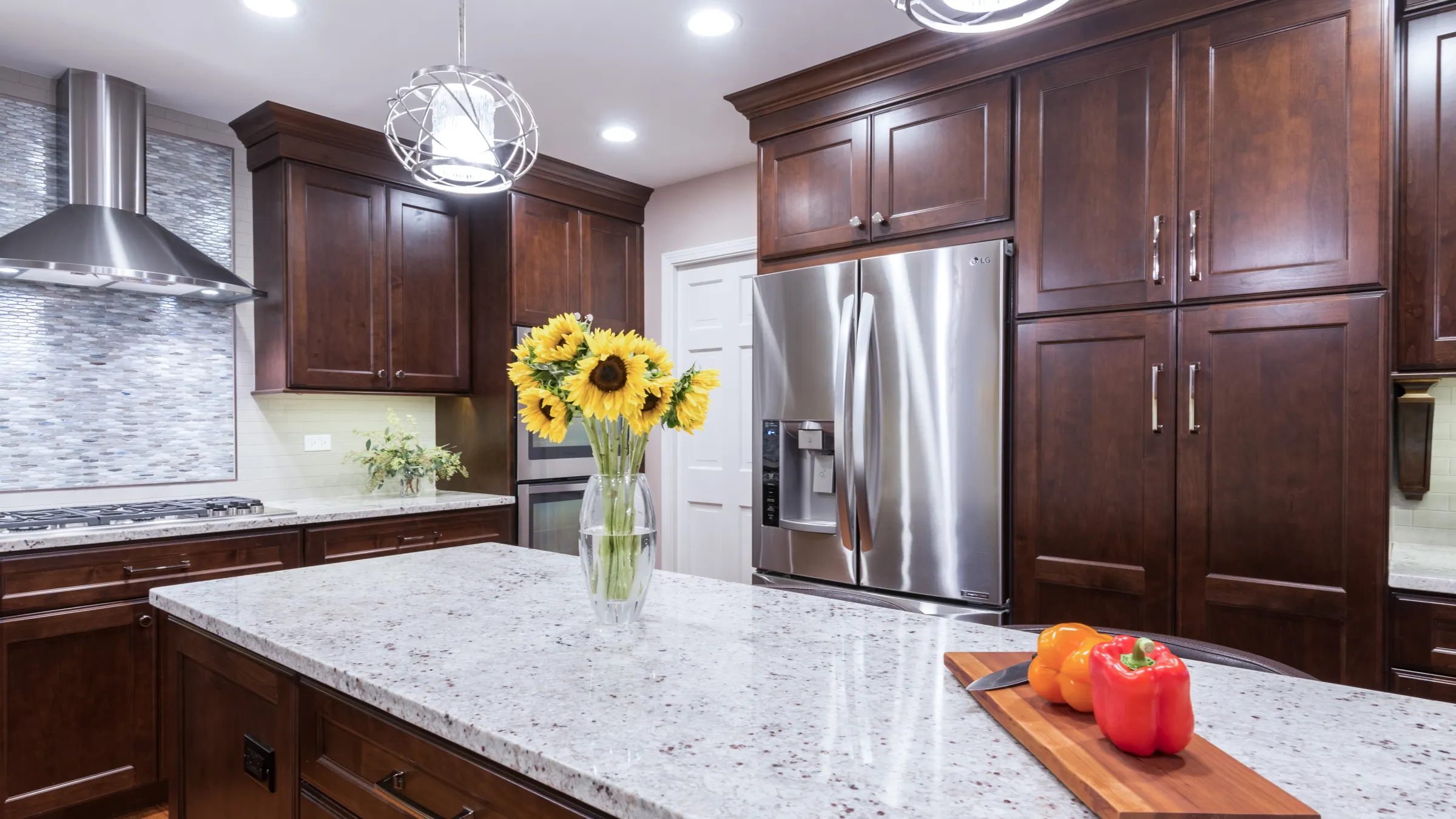Kitchen remodel with dark wood cabinets, granite countertops, stainless steel appliances, and sunflowers. Palatine, IL.