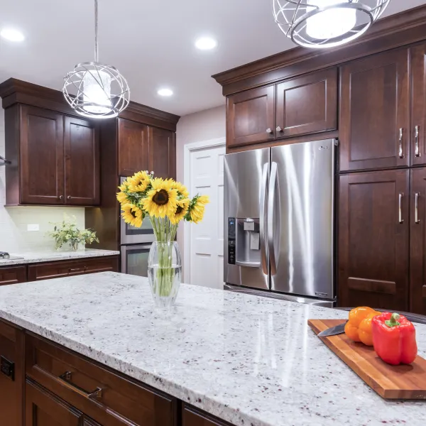 Kitchen remodel with dark wood cabinets, granite countertops, stainless steel appliances, and sunflowers. Palatine, IL.