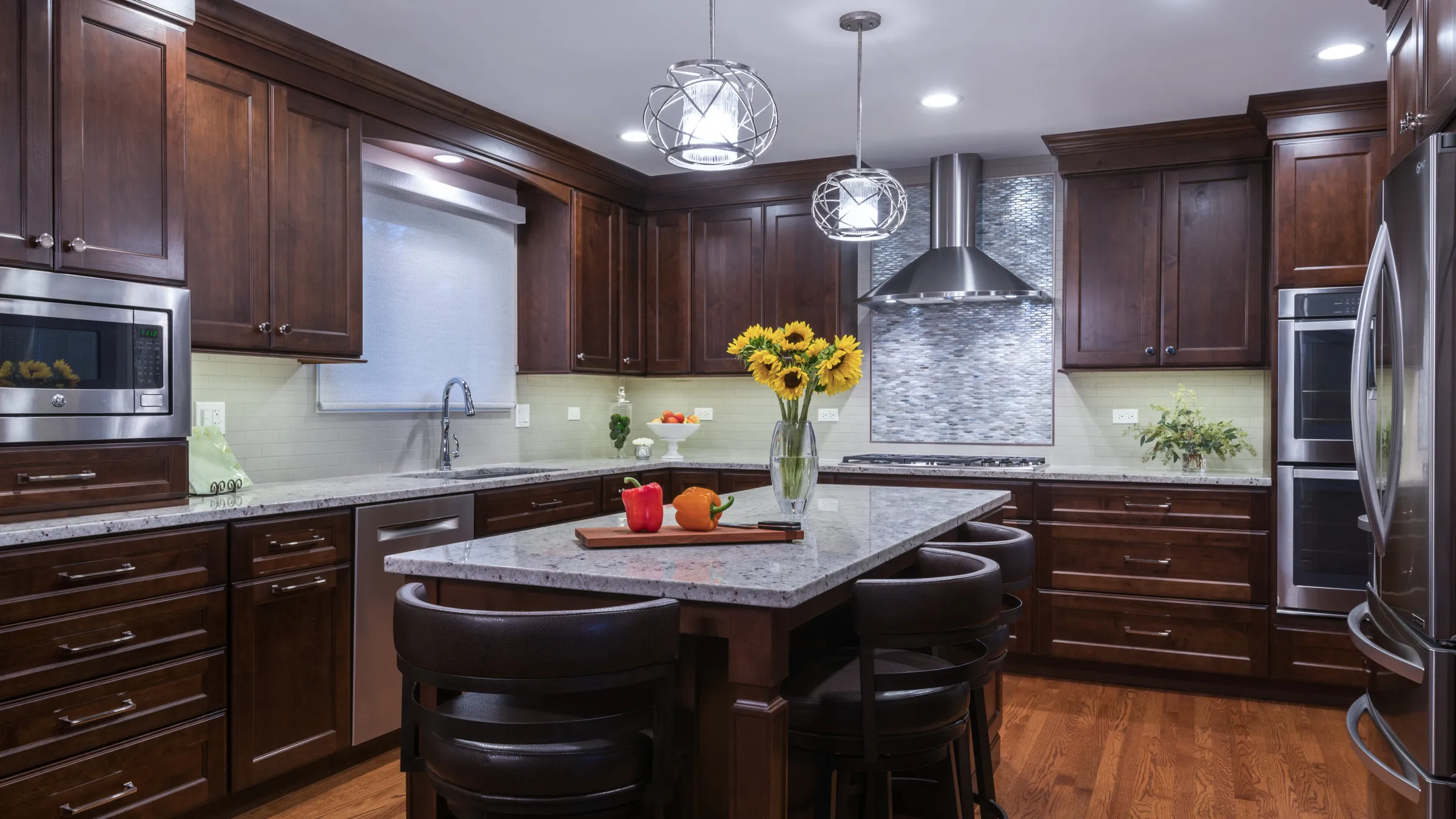 Kitchen remodel in Palatine, IL featuring dark wood cabinets, granite countertops, stainless steel appliances, and hardwood f