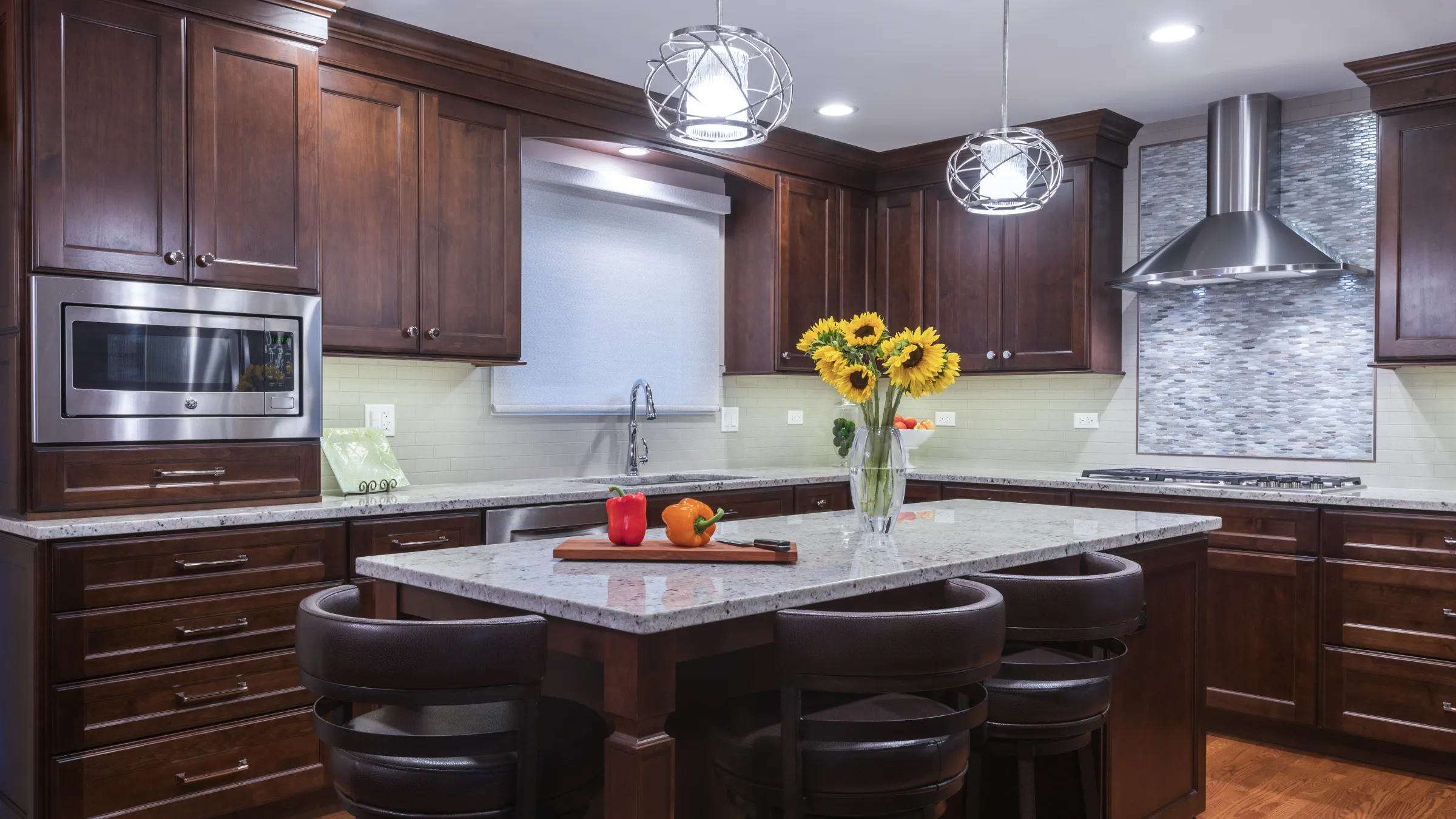 Beautiful kitchen remodel in Palatine, IL. Features dark wood cabinets, granite countertops, and stainless steel appliances.
