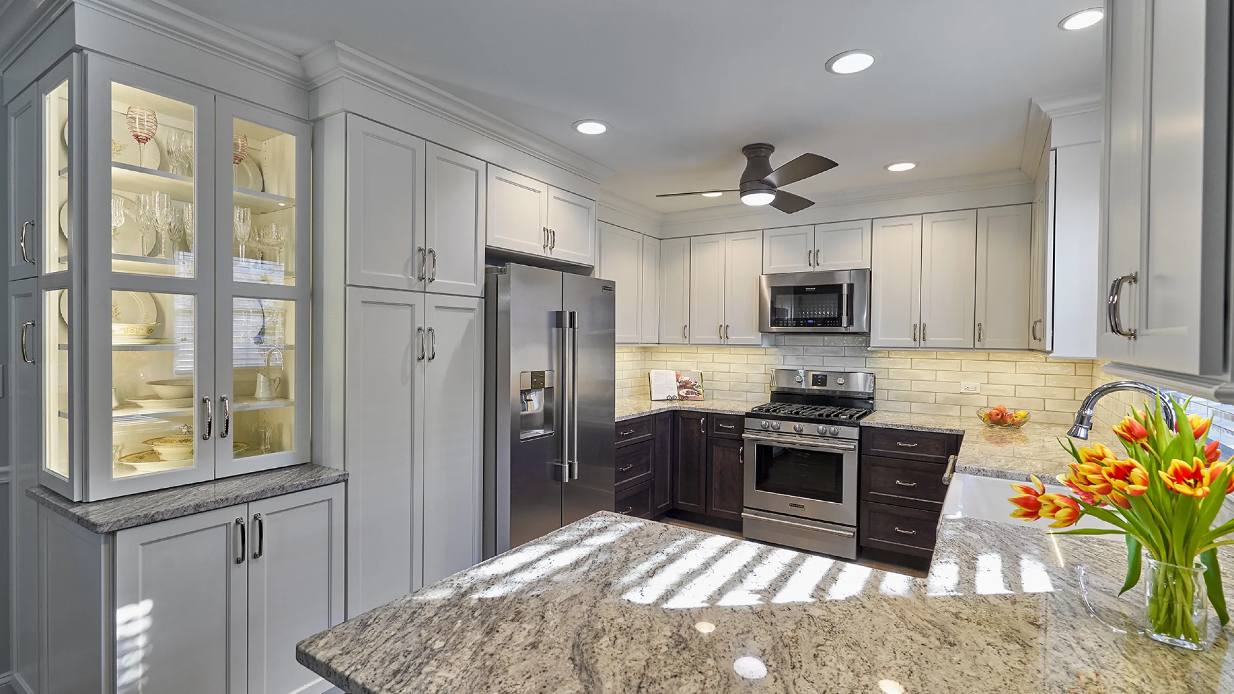 Lake Zurich kitchen remodel: white cabinets, granite countertops, stainless steel appliances, and a stylish ceiling fan.