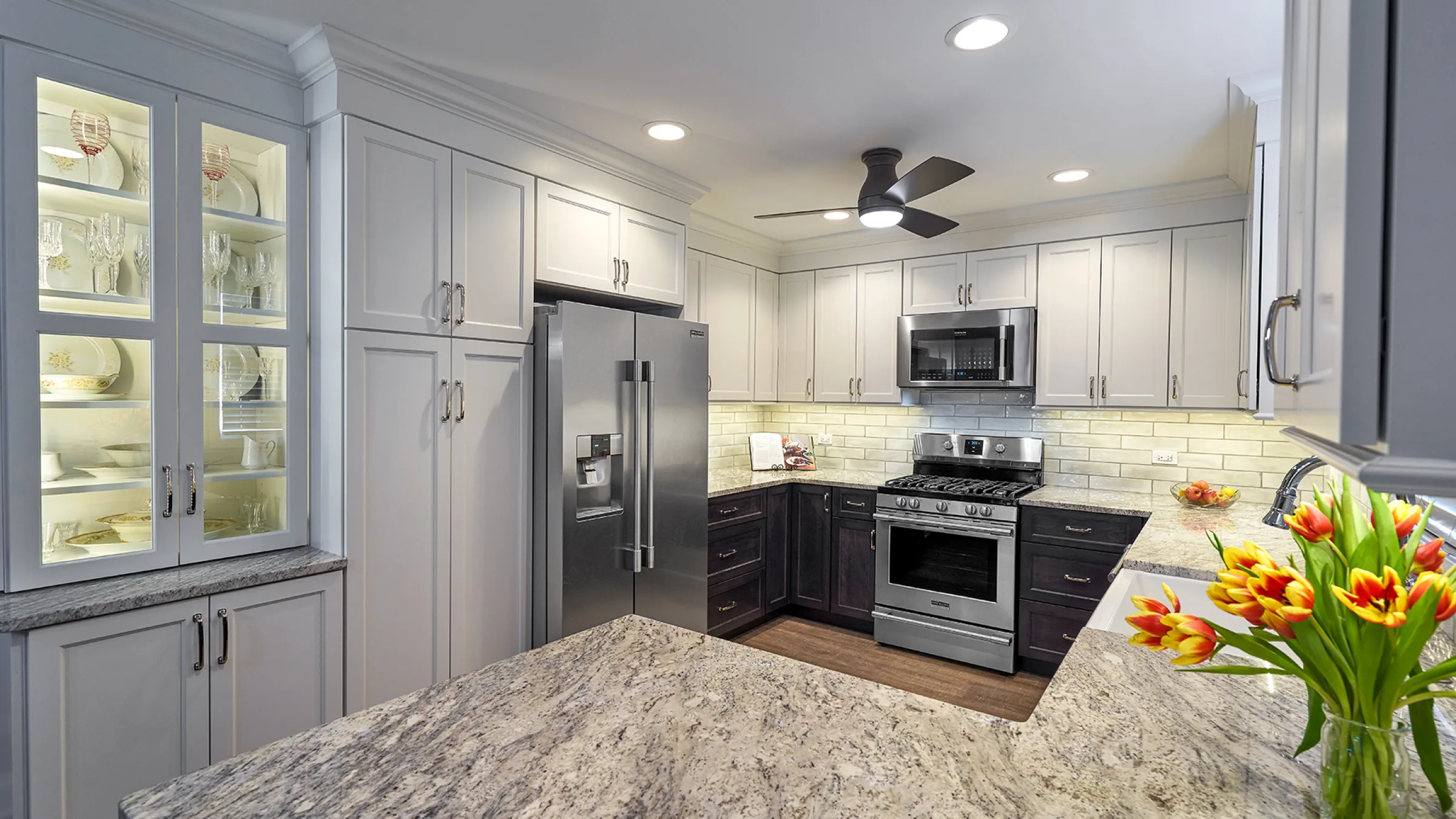 Lake Zurich kitchen remodel: gray cabinets, granite counters, stainless steel appliances, and dark wood flooring.