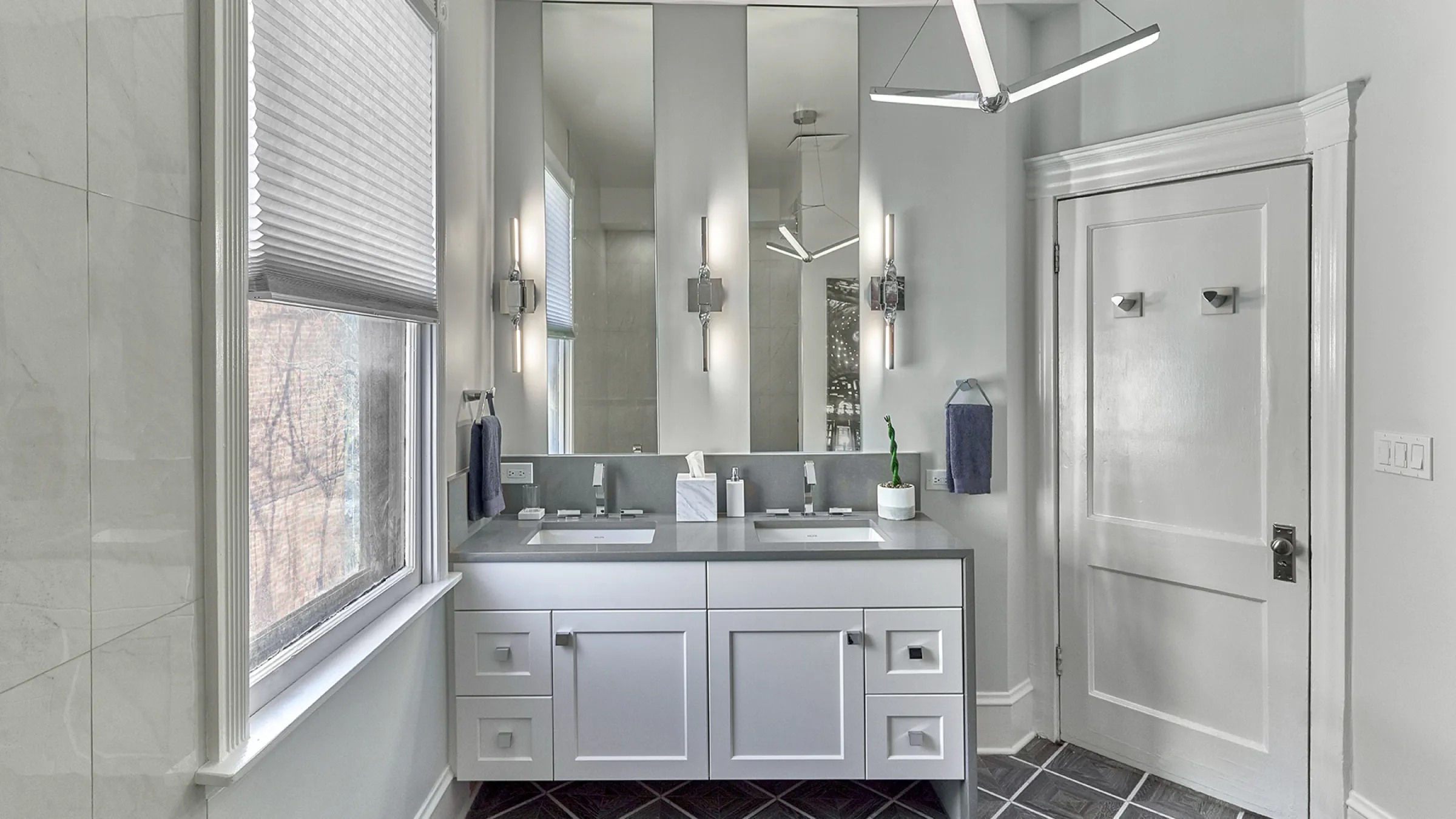 Chicago bathroom remodel with double vanity, gray countertops, modern lighting, and stylish flooring.