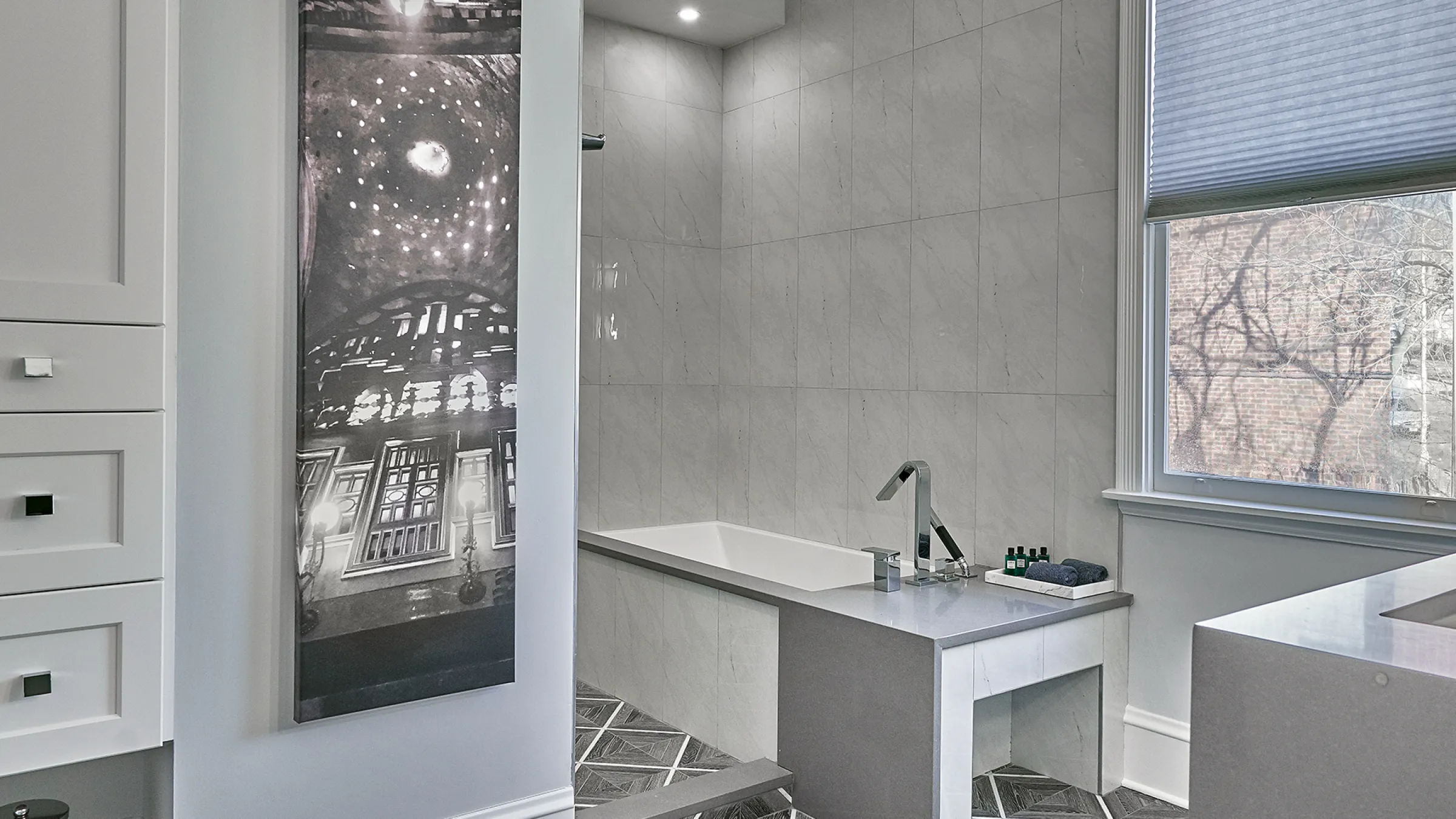 Chicago bathroom remodel: freestanding tub, gray tile, modern fixtures, and elegant black & white art.