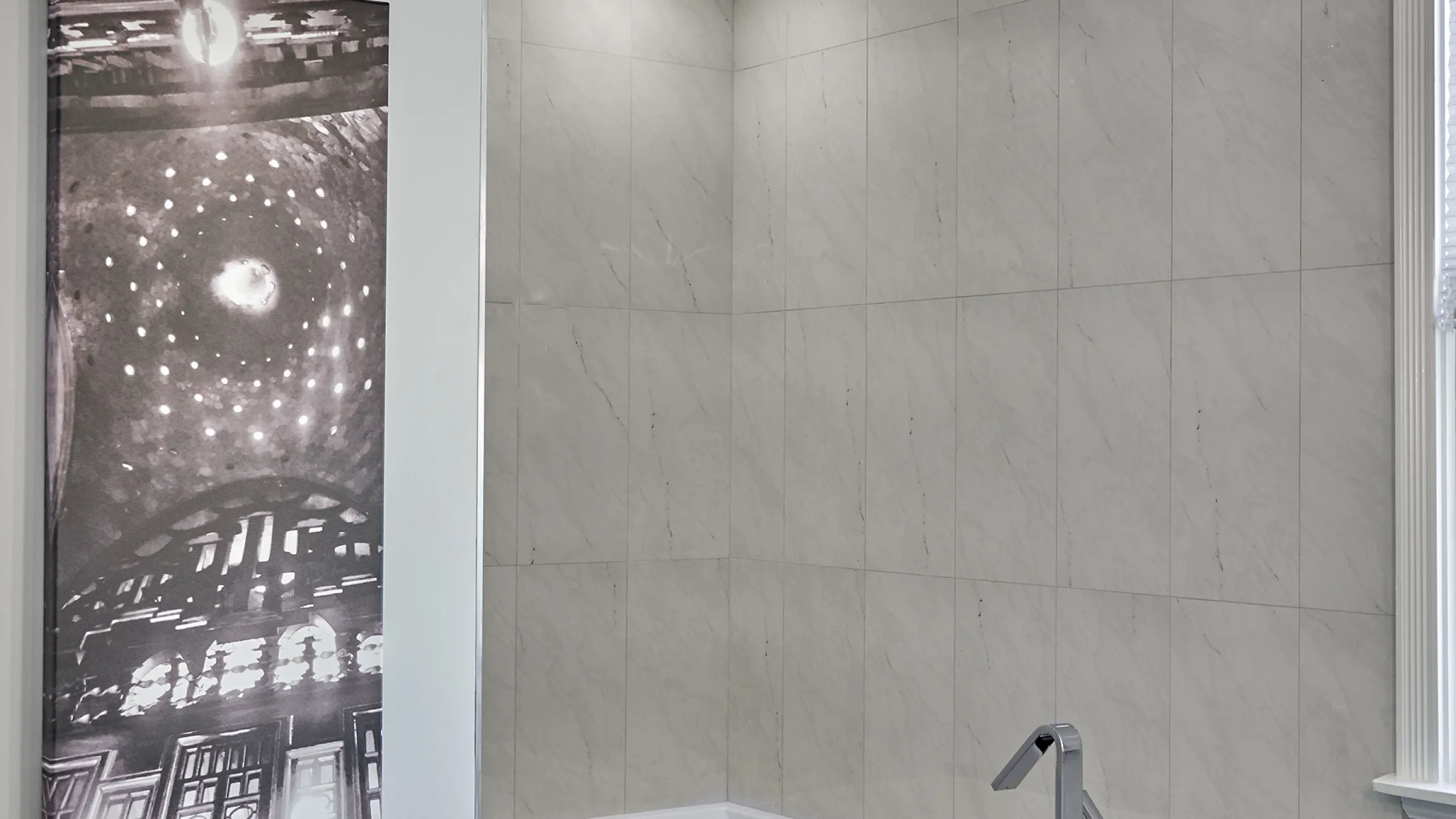Chicago bathroom remodel featuring marble-look tile walls and modern chrome faucet.