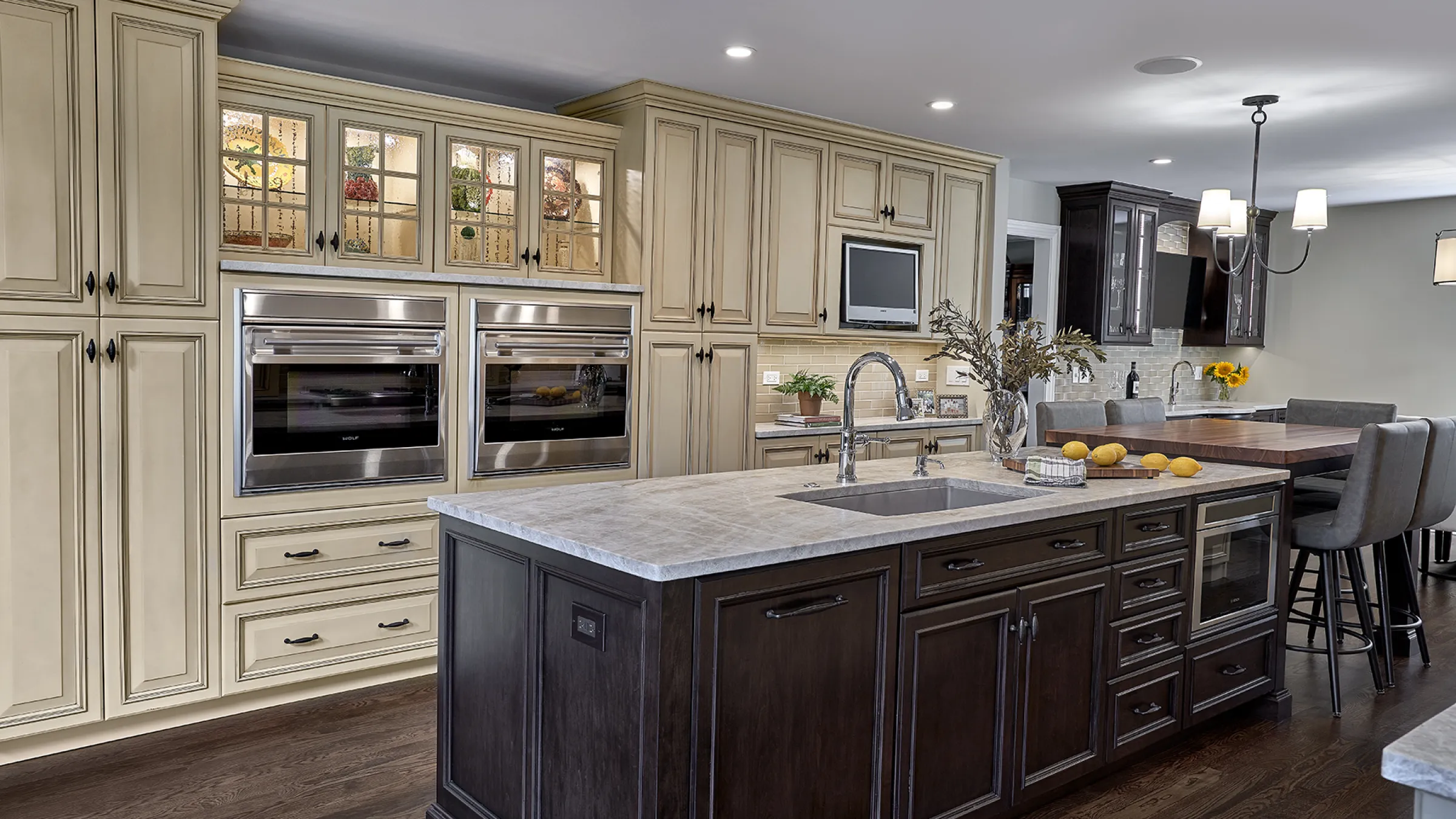 Inverness kitchen remodel featuring cream cabinets, a dark island, marble countertops, and stainless steel appliances.