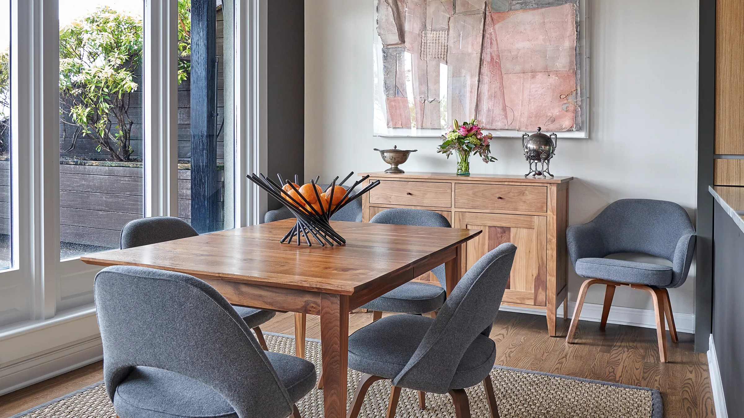 Chicago dining room remodel with wood table, gray chairs, natural rug, and custom wood storage cabinet.