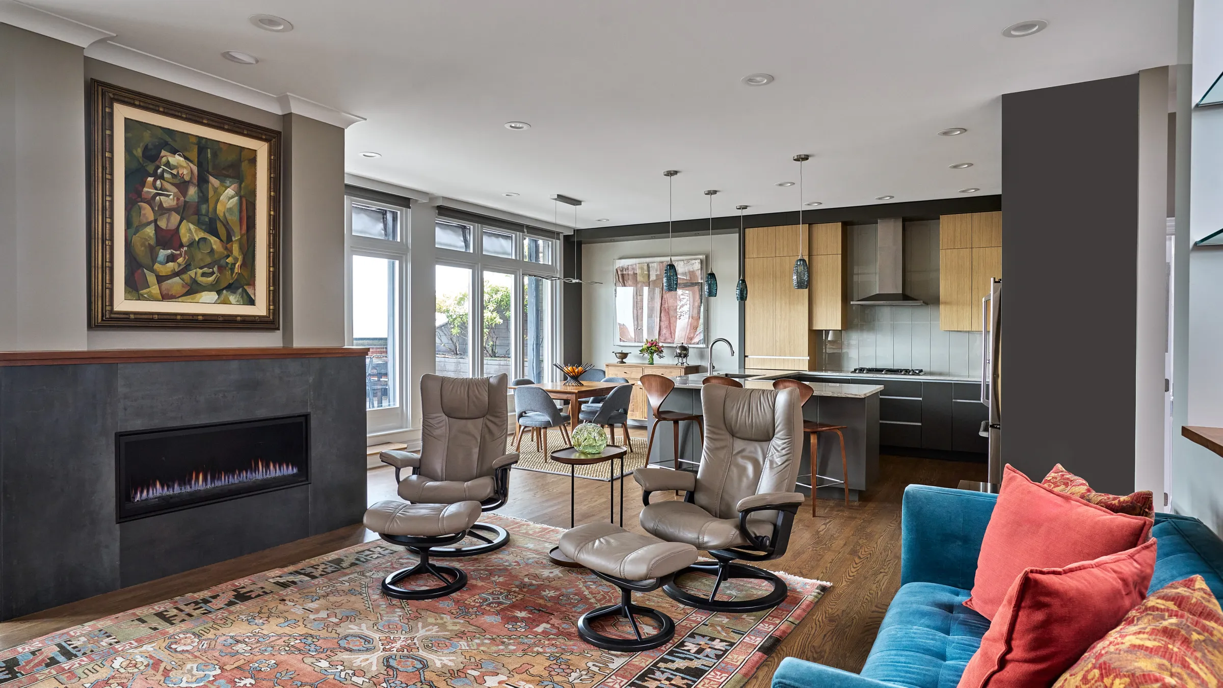 Modern condo renovation featuring open-concept living, dining, and kitchen areas in Chicago. Fireplace, wood floors, & lounge