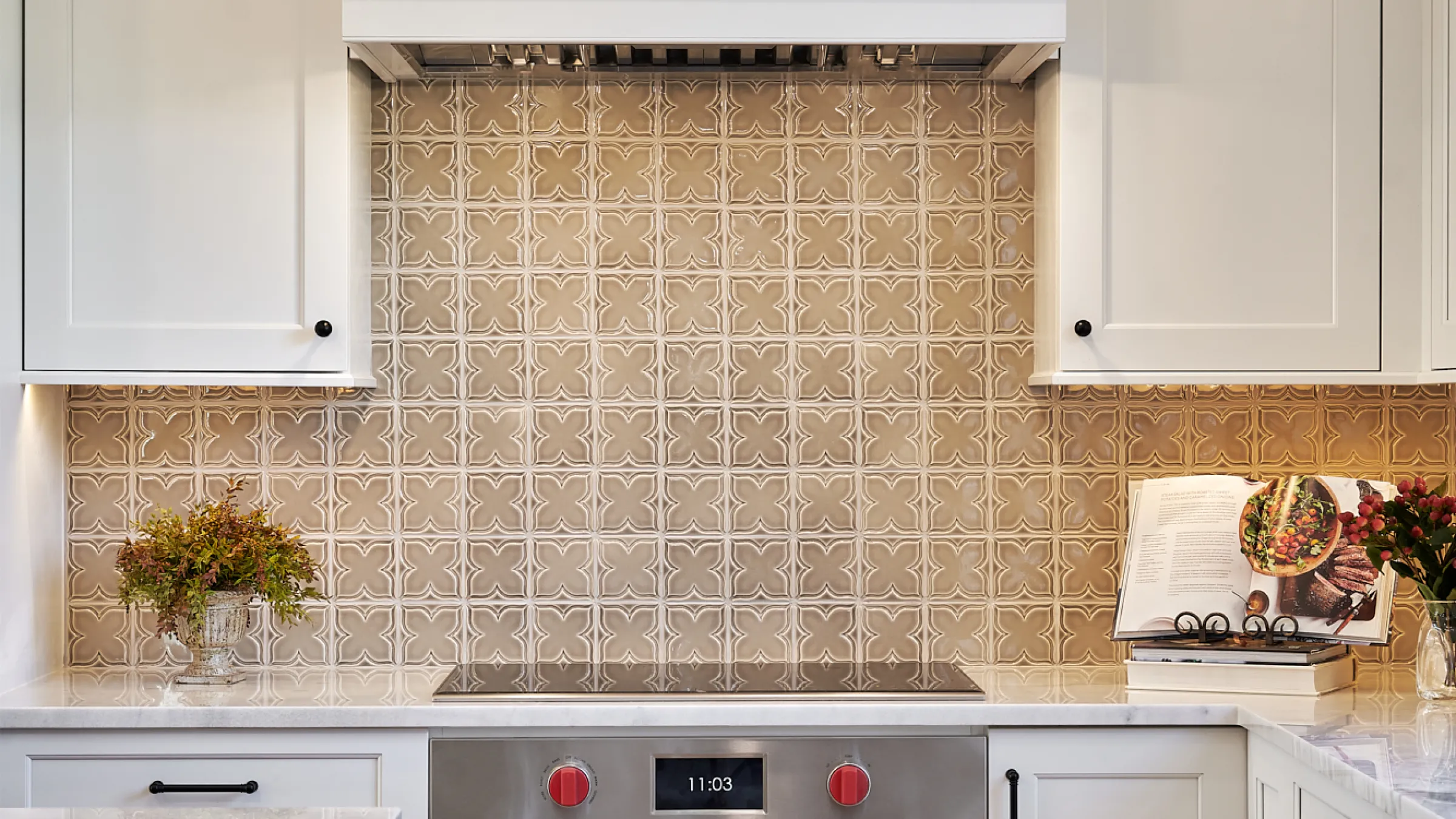 Kitchen remodel in Barrington, IL featuring custom white cabinets, patterned backsplash, and stainless steel stove.