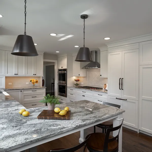 Bright kitchen remodel with white cabinets, granite countertops, pendant lighting, and stainless steel appliances.