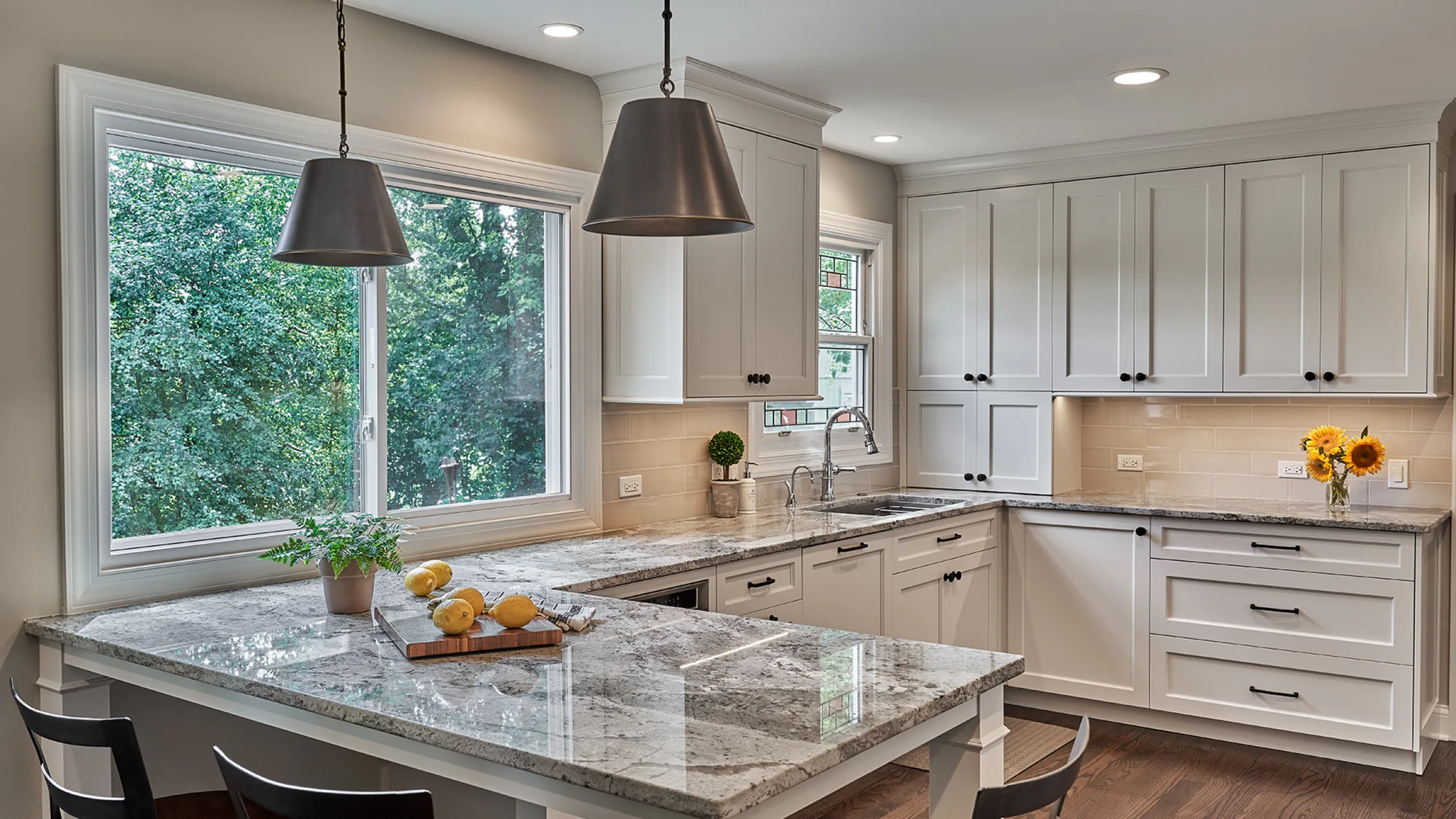 Bright kitchen remodel in Hoffman Estates featuring white cabinets, granite countertops, and stainless steel fixtures.