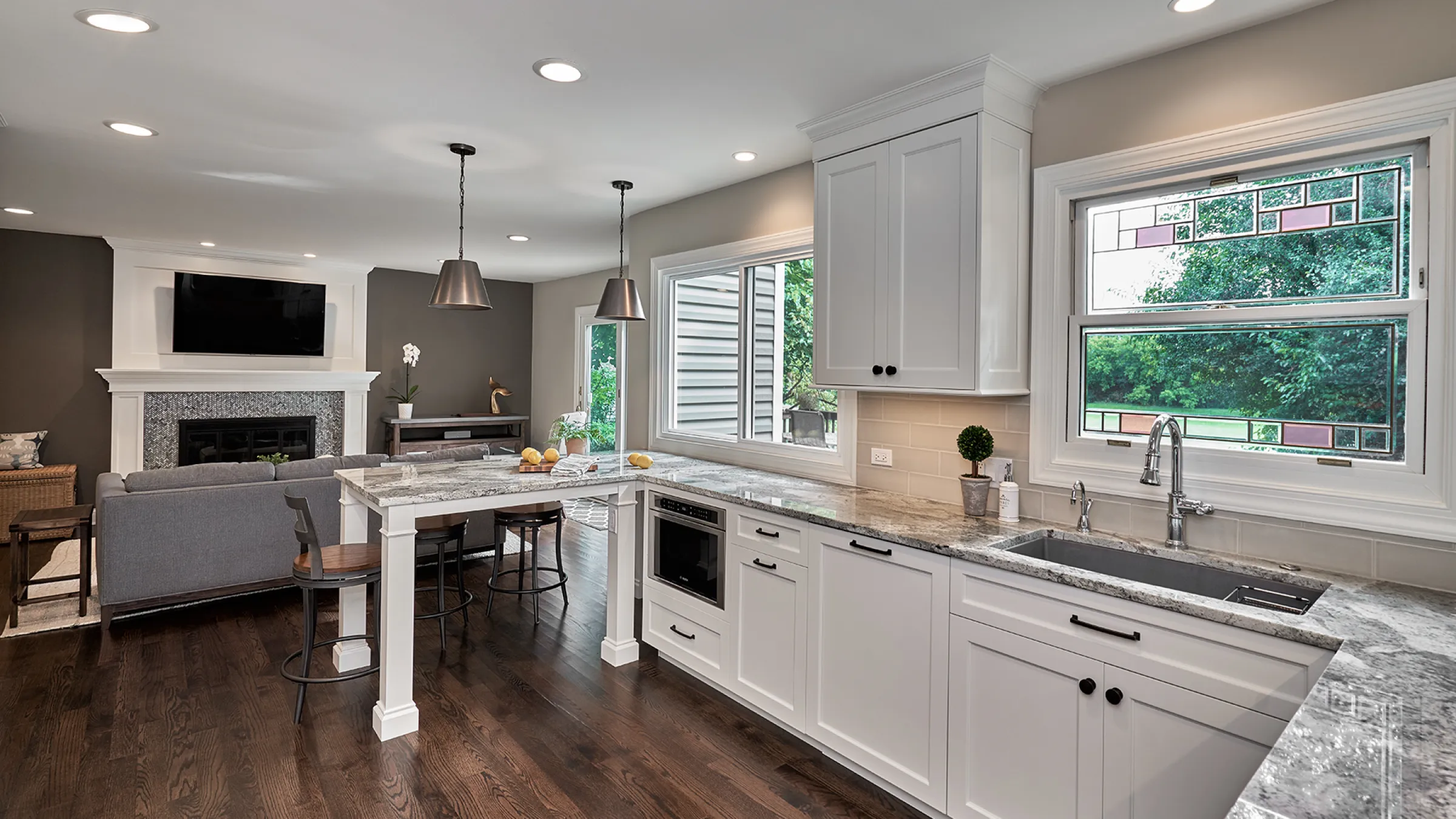 Bright, open kitchen remodel with granite counters, white cabinets, and hardwood floors in Hoffman Estates, IL.