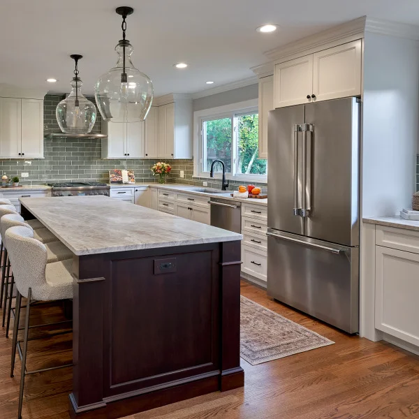 Inverness kitchen remodel featuring white cabinets, marble countertops, wood floors, and a dark wood island with seating.