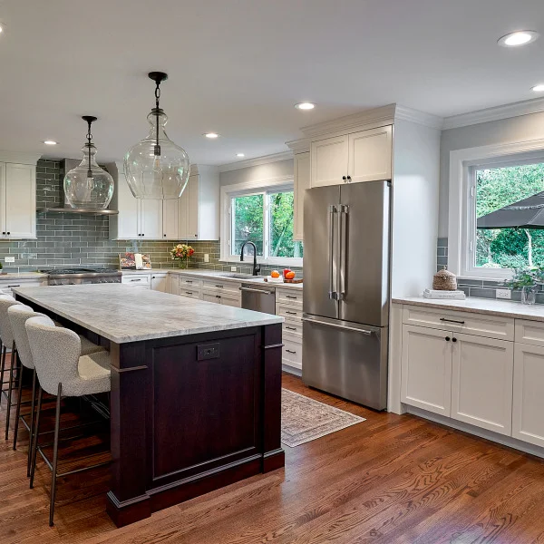 Inverness kitchen remodel: white cabinets, gray backsplash, wood floors, marble island, stainless steel appliances.
