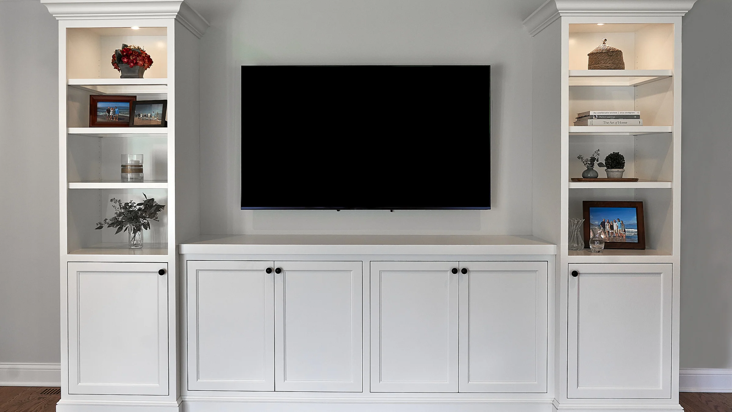 Inverness home remodel: Custom white built-in entertainment center with shelving and cabinets.