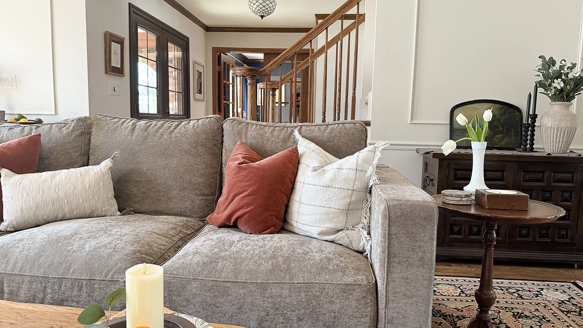 Living room interior featuring a comfortable couch with pillows, a side table, and decorative elements.