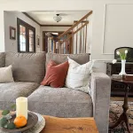 Living room interior featuring a comfortable couch with pillows, a side table, and decorative elements.