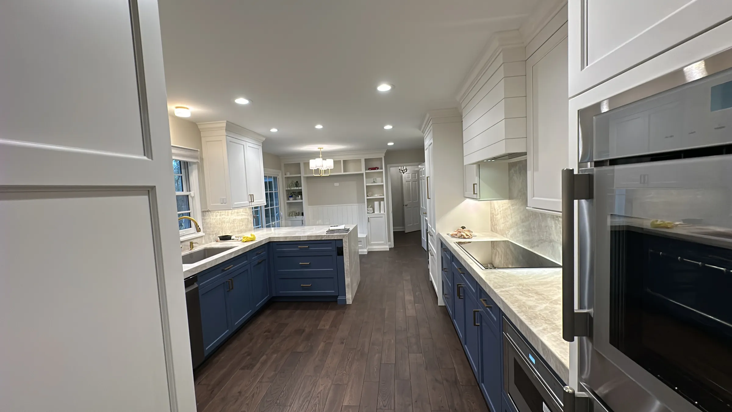 Barrington kitchen remodel featuring blue lower cabinets, white upper cabinets, and hardwood floors.