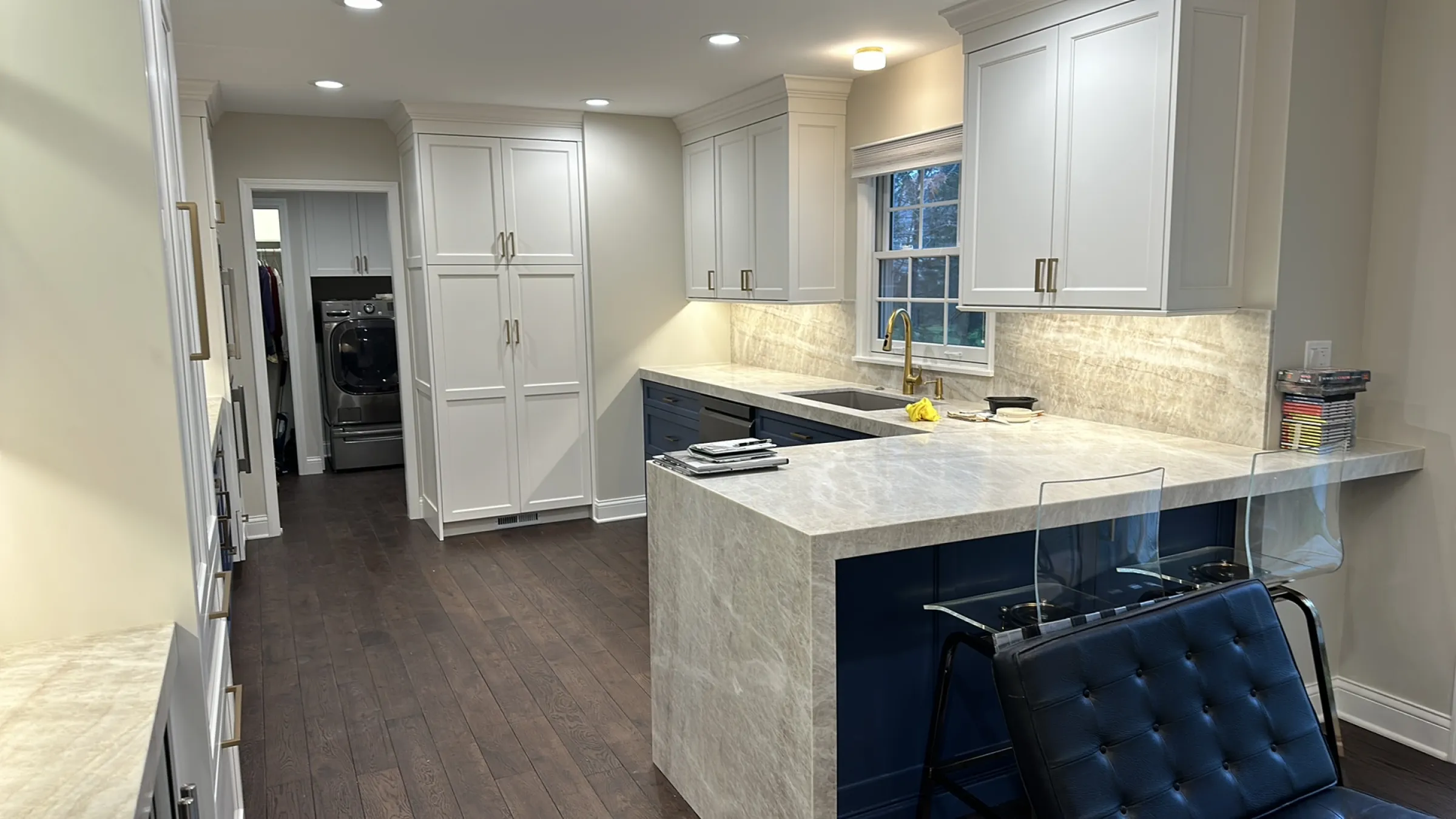 Barrington kitchen remodel with white cabinets, dark wood floors, stone countertops, and a kitchen island.