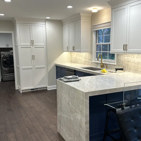 Barrington kitchen remodel with white cabinets, dark wood floors, stone countertops, and a kitchen island.