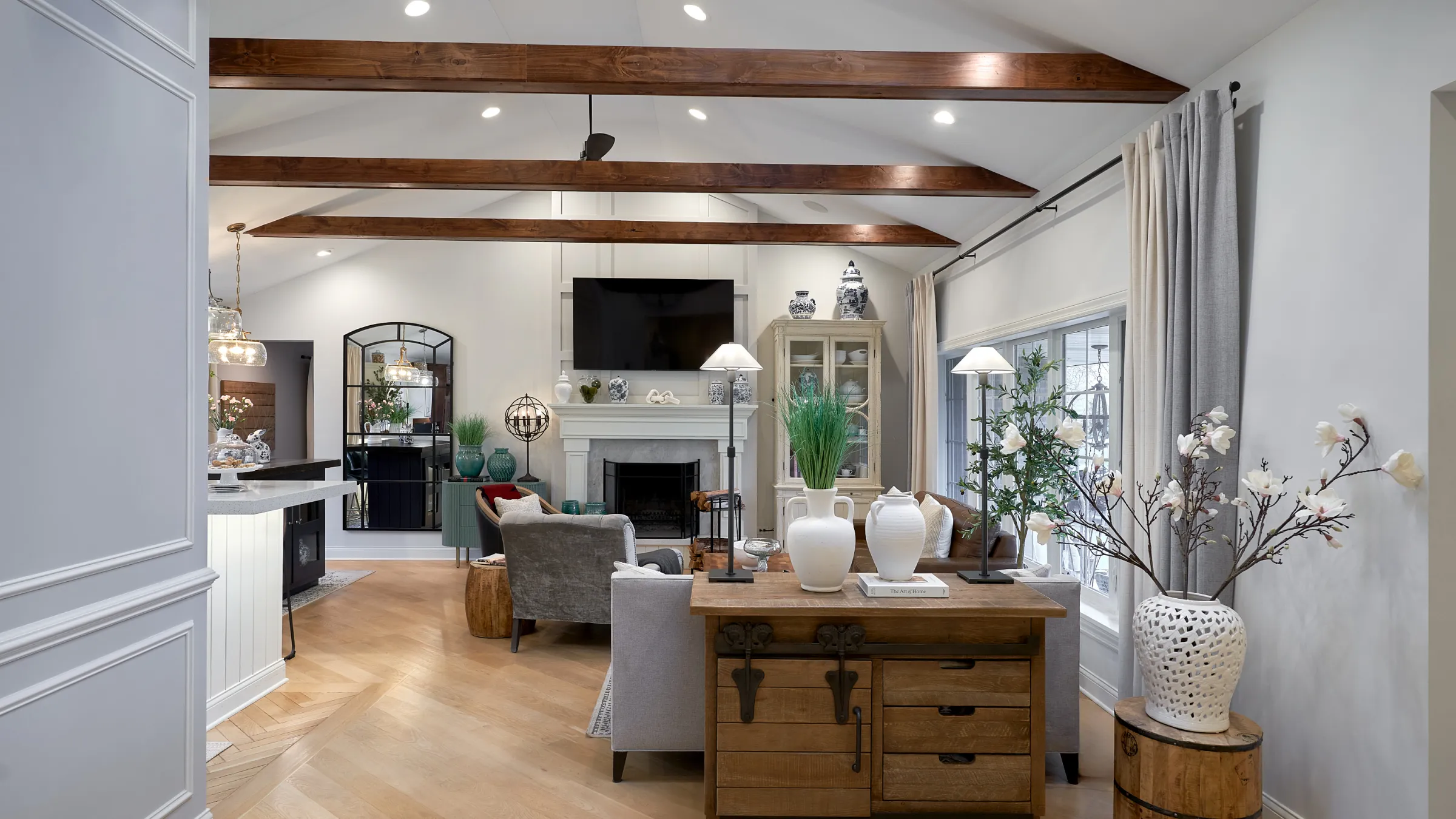 Bright living room remodel with wood beams, herringbone floors, fireplace, and modern decor. Prospect Heights, IL.