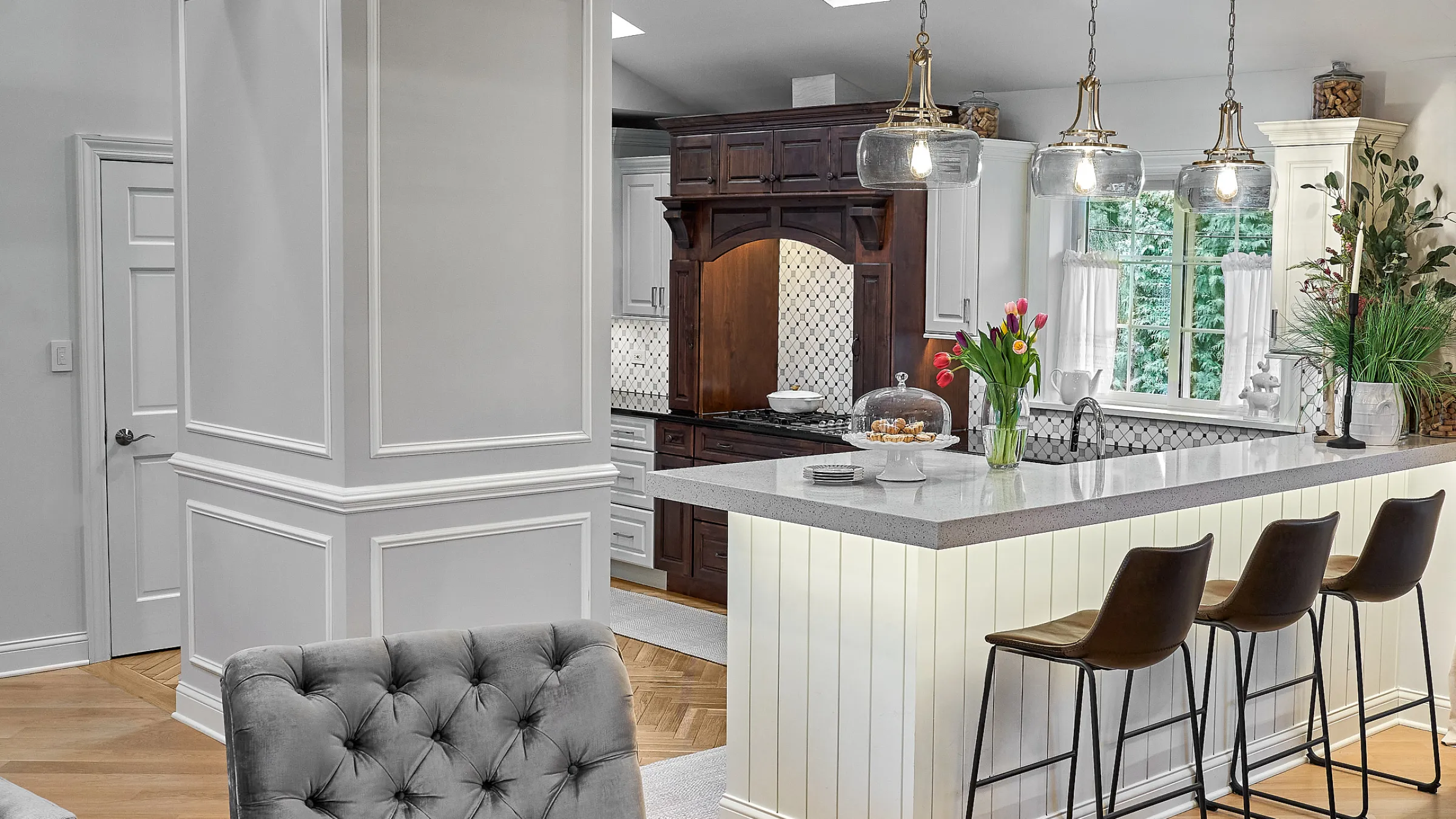 Remodeled kitchen with herringbone floors, gray quartz countertops, and custom cabinetry in Prospect Heights, IL.