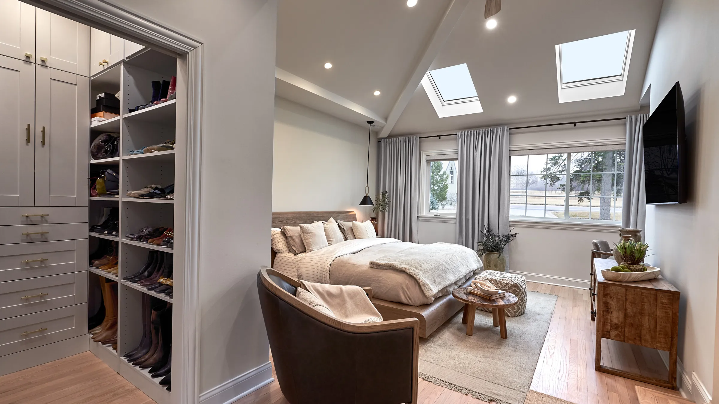 Prospect Heights bedroom remodel with custom closet, wood floors, skylights, and modern furnishings.