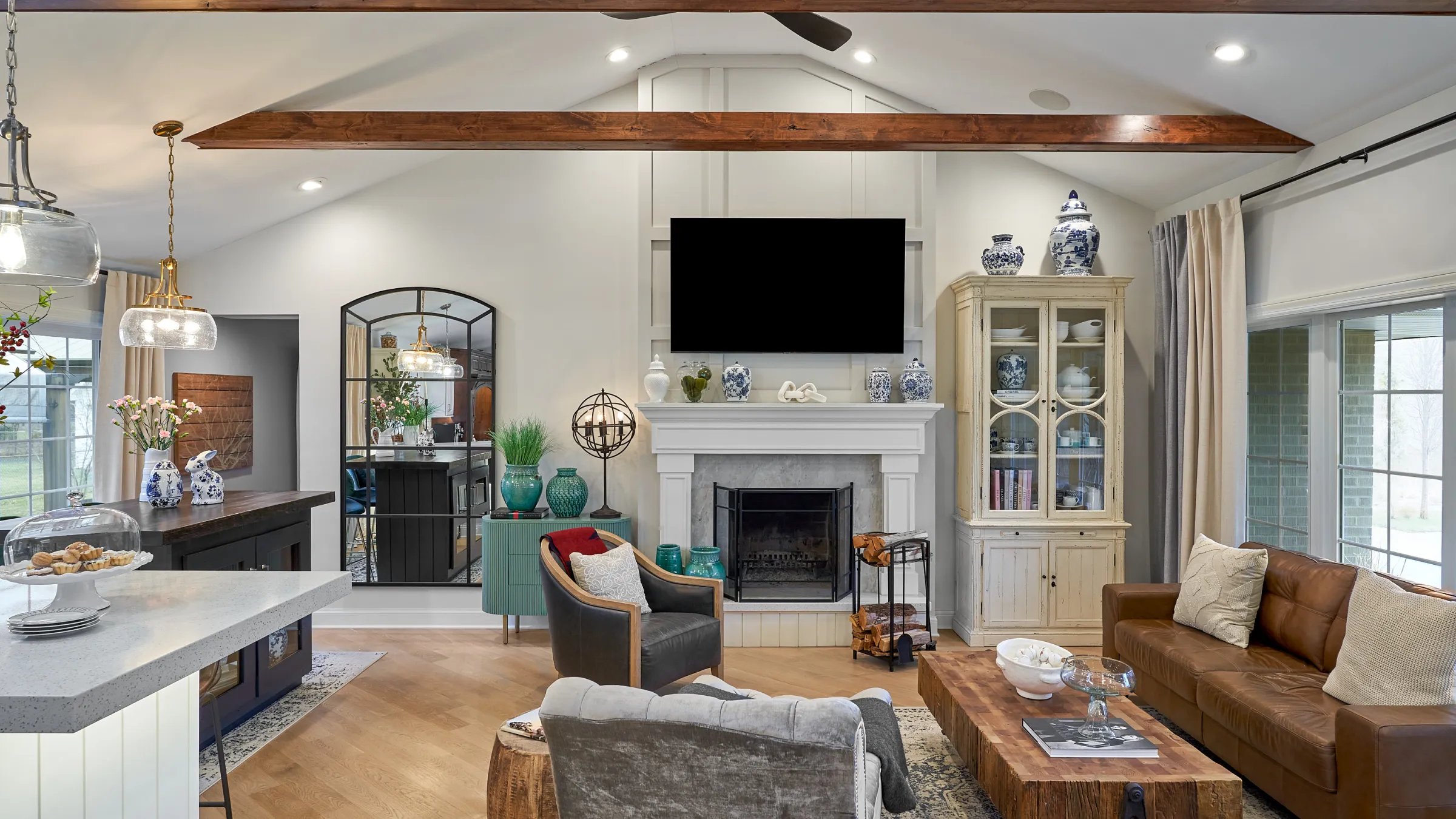 Prospect Heights home remodel: living room with wood beams, fireplace, herringbone floors, custom cabinets, & stylish furnitu