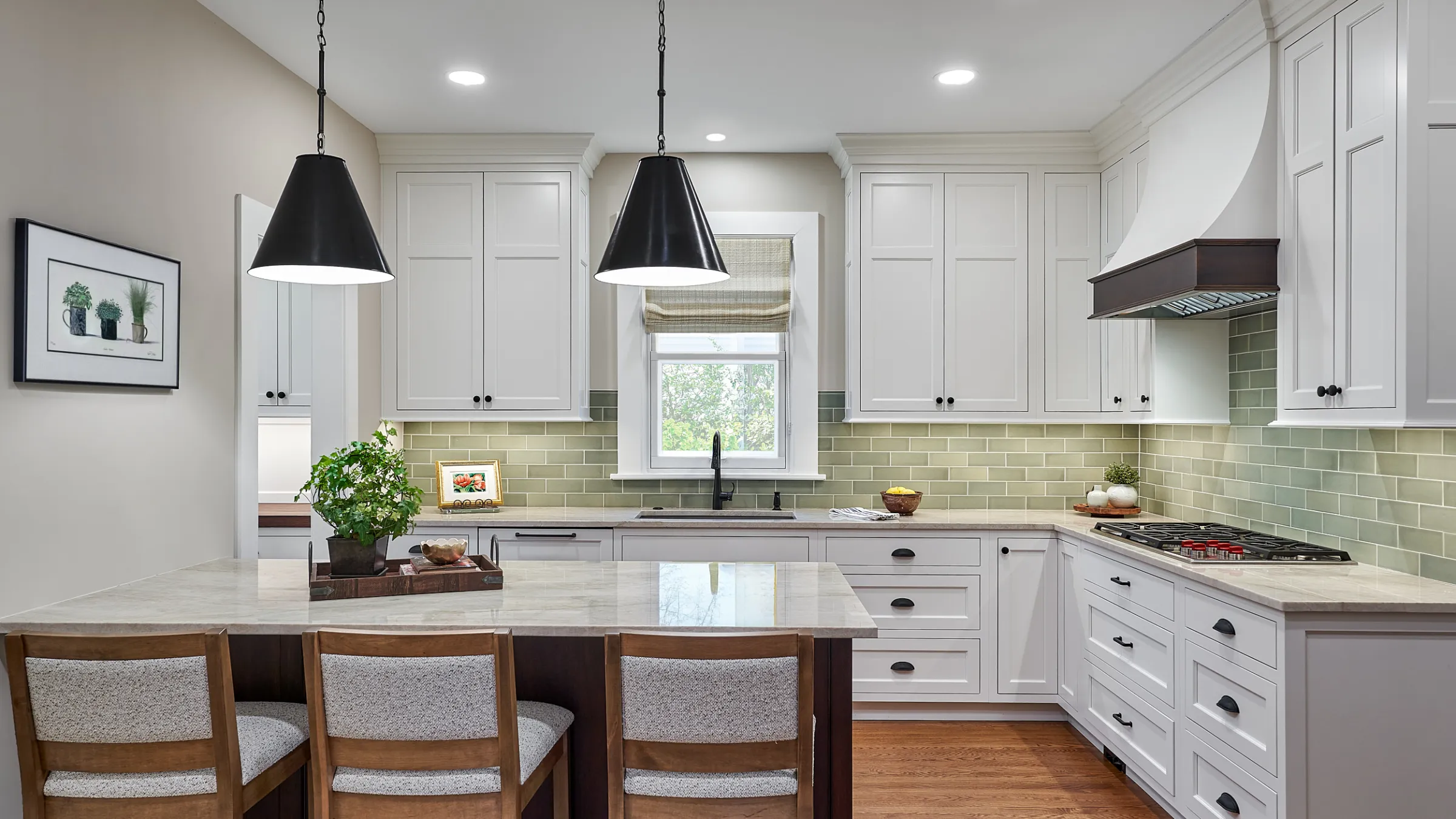 White kitchen remodel with shaker cabinets, green subway tile backsplash, granite countertop, and wood floors.
