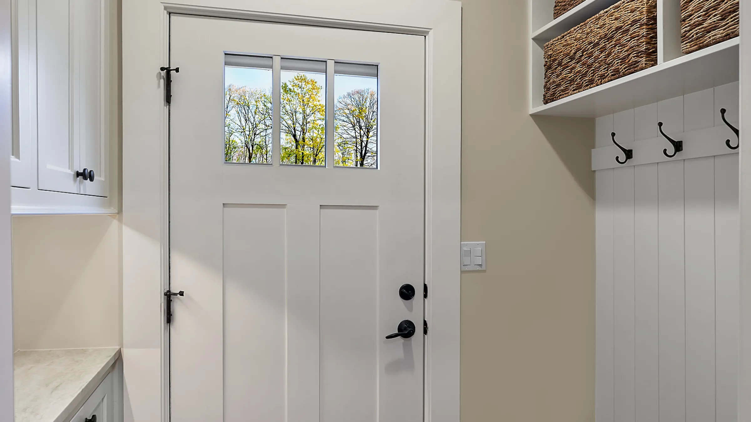 White kitchen door with window, black hardware, and coat rack in a Palatine, IL kitchen remodel.