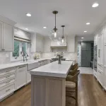 Bright white kitchen with shaker cabinets, quartz countertops, subway tile backsplash, farmhouse sink, wood island, and penda