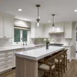 Modern white kitchen with shaker cabinets, quartz countertops, wood island, farmhouse sink, pendant lights, and wood flooring