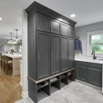 Modern open-concept first floor remodel featuring a laundry room with dark gray shaker cabinets, utility sink, washer, and mu