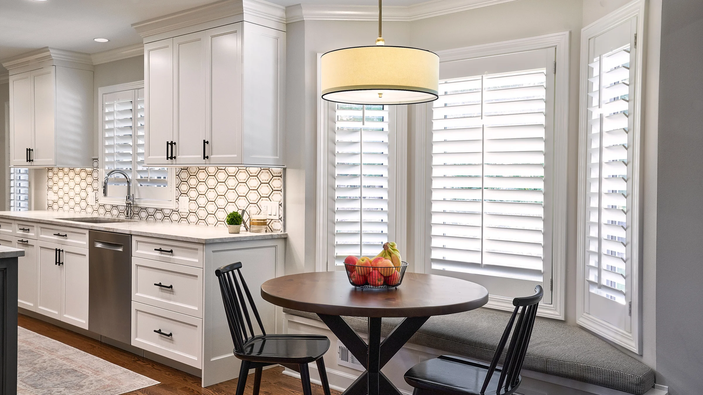 Bright kitchen remodel in Palatine, IL featuring white cabinets, hexagon tile backsplash, and breakfast nook with window seat