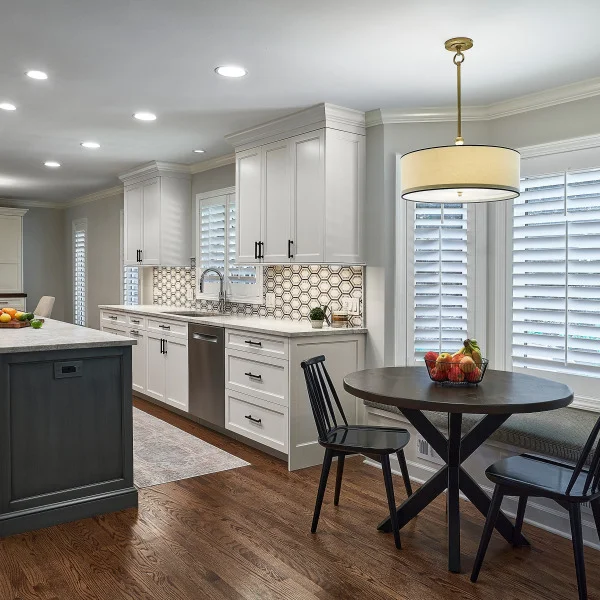 Bright kitchen remodel with white cabinets, dark island, wood floors, and breakfast nook in Palatine, IL.