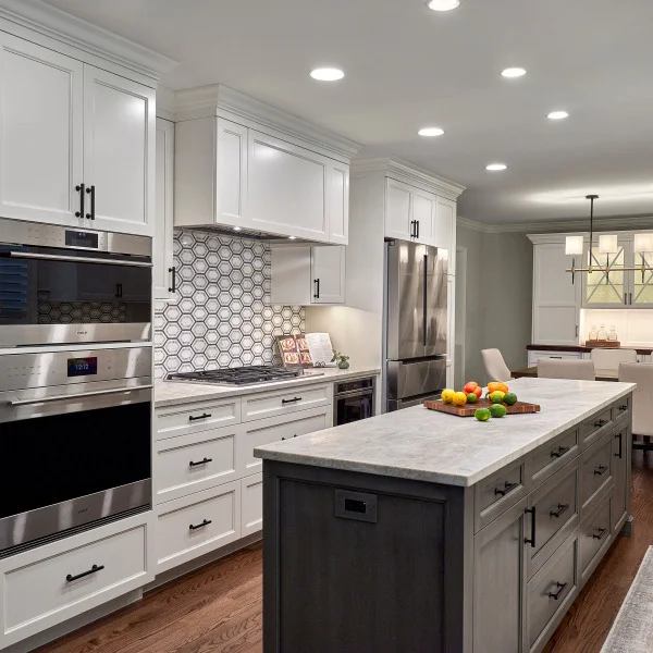 Palatine, IL Kitchen Remodel: White cabinets, gray island, stainless steel appliances, hardwood floors, and modern lighting.
